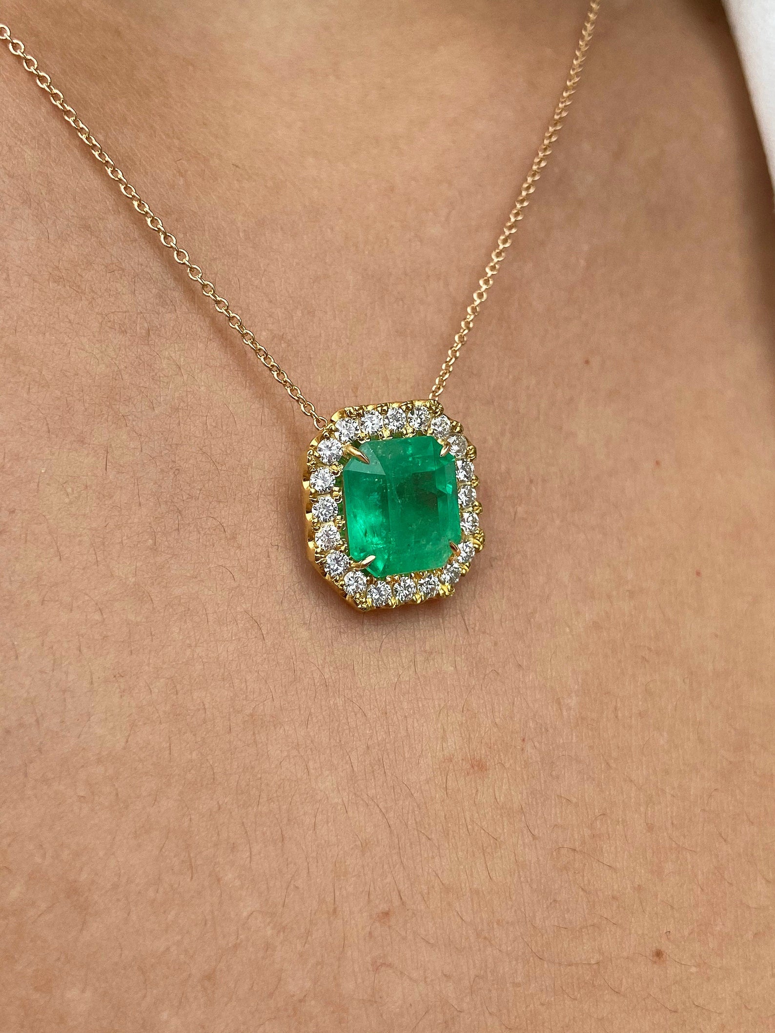 Square cut natural Colombian emerald and diamond halo pendant necklace in 14k yellow gold, featuring 4.60tcw emeralds and sparkling diamonds.