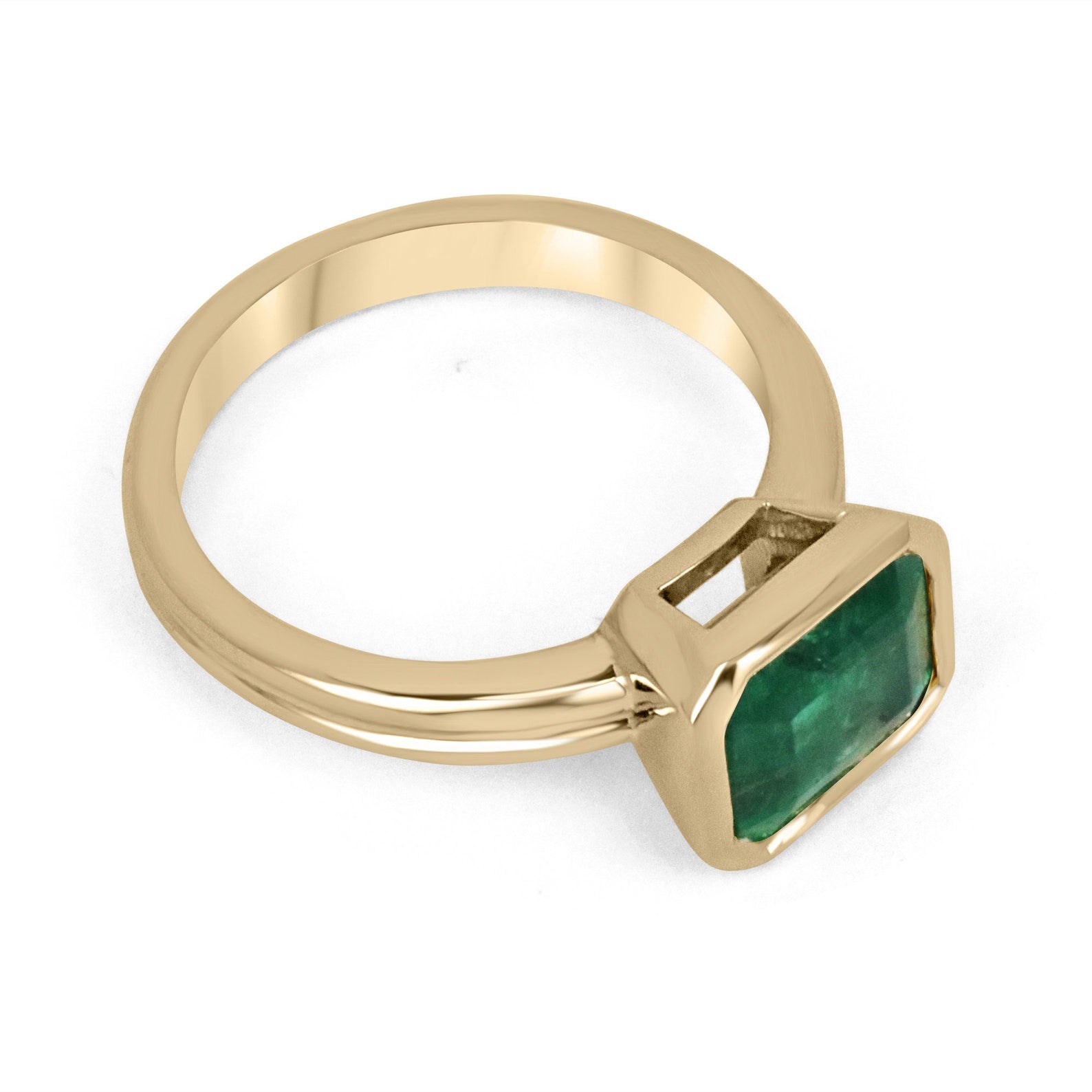 East-to-west 2.75ct dark vivid green emerald bezel solitaire ring in 18K gold by JR Colombian Emeralds.