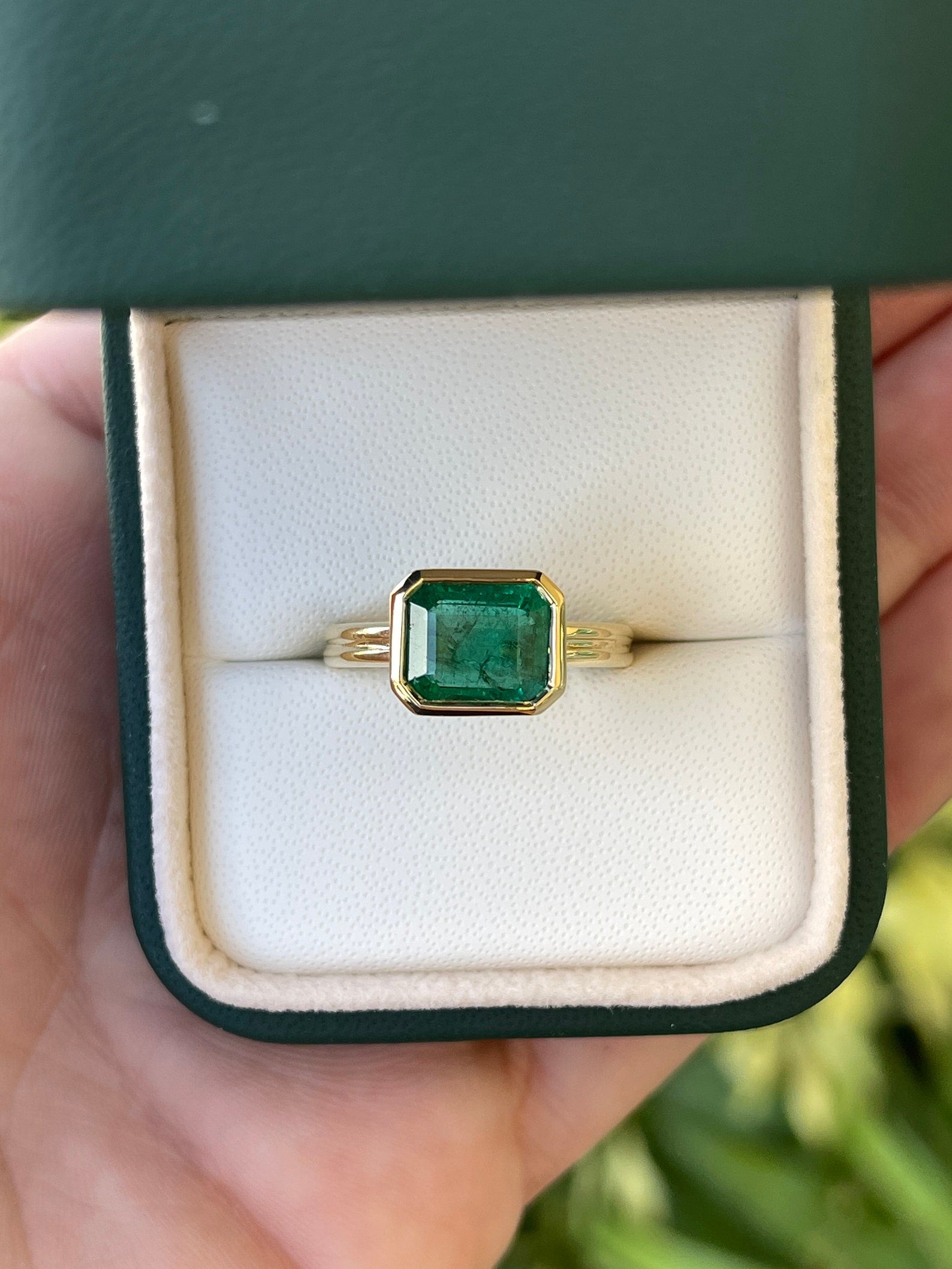 Natural 2.75ct east-west dark vivid green emerald bezel solitaire ring in 18K gold from JR Colombian Emeralds.