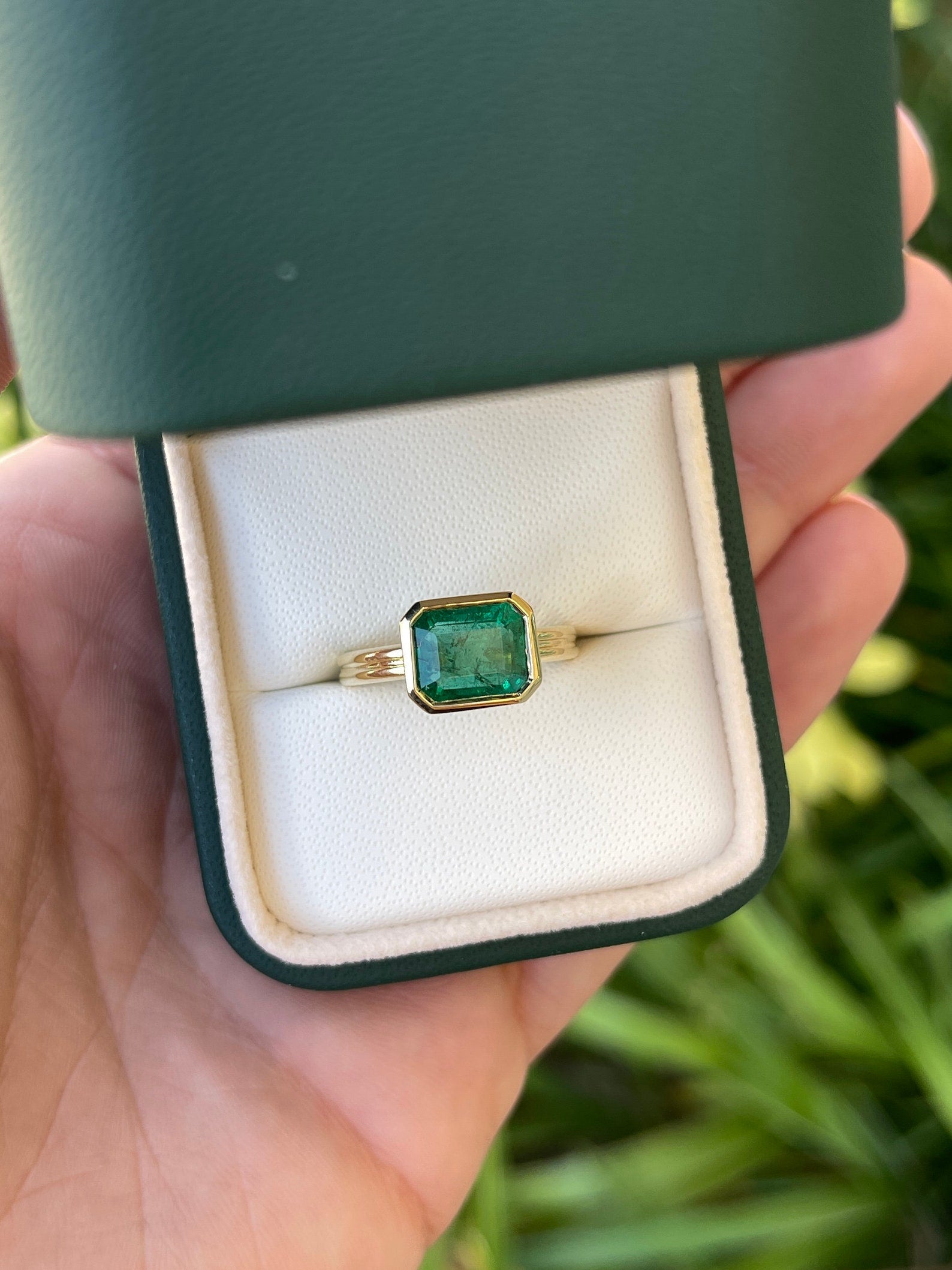 Natural dark green emerald bezel solitaire ring featuring a 2.75ct east-to-west cut, set in 18K gold by JR Colombian Emeralds.