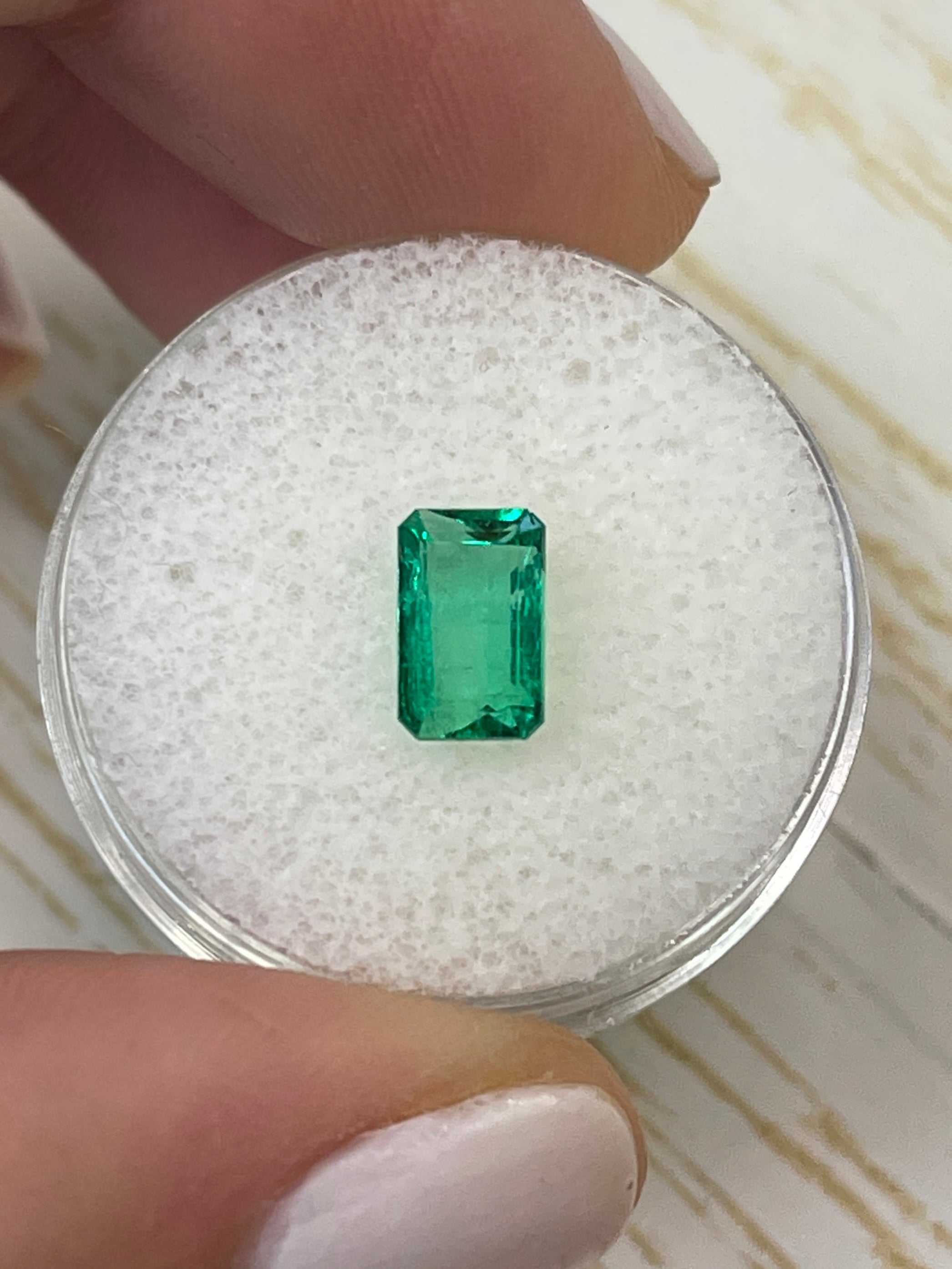 1.50 carat elongated Muzo green Colombian emerald loose gemstone in emerald cut, natural and vibrant green color.