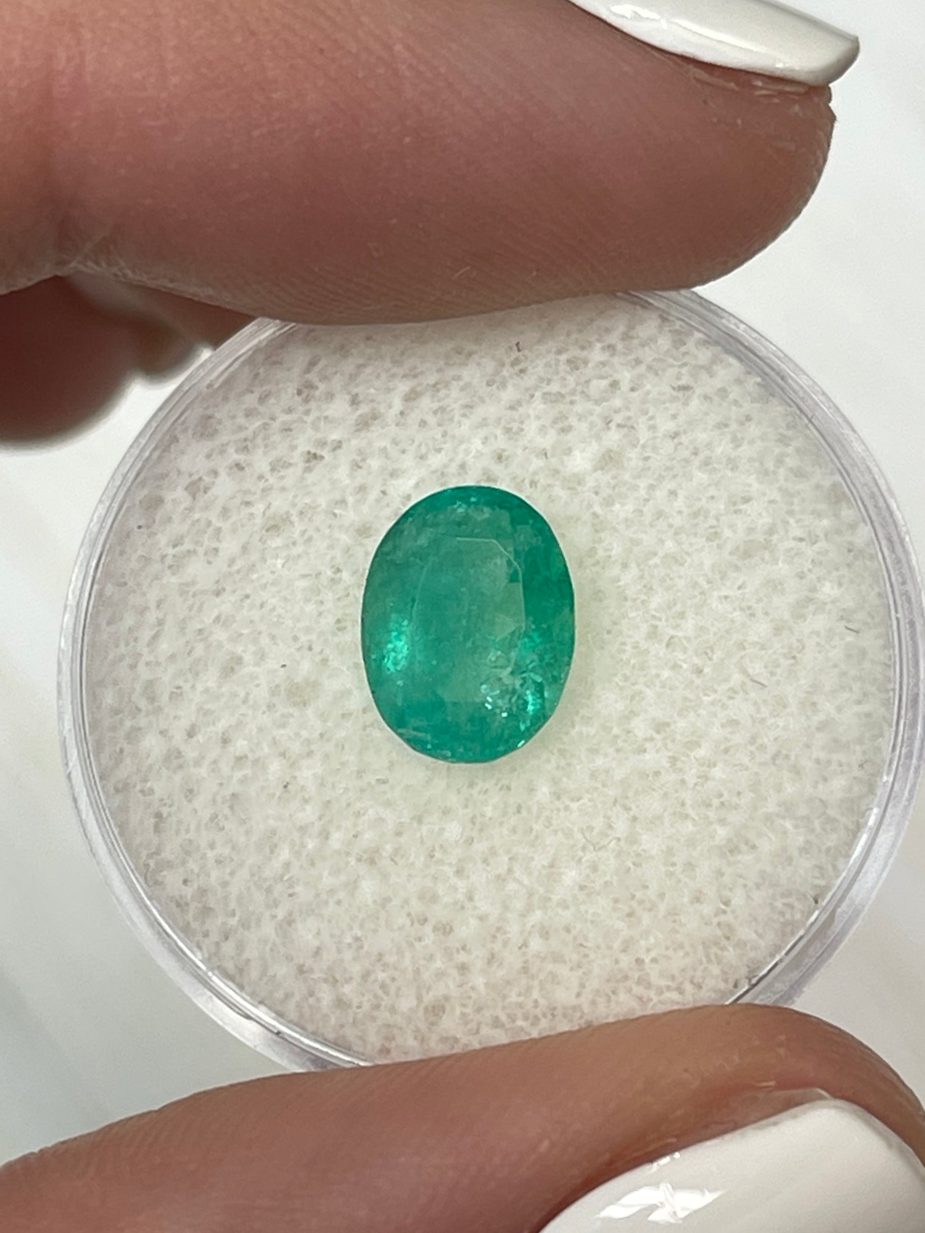 Oval cut 1.63 carat bluish green Colombian emerald gemstone with natural cloudy appearance, from JR Colombian Emeralds.