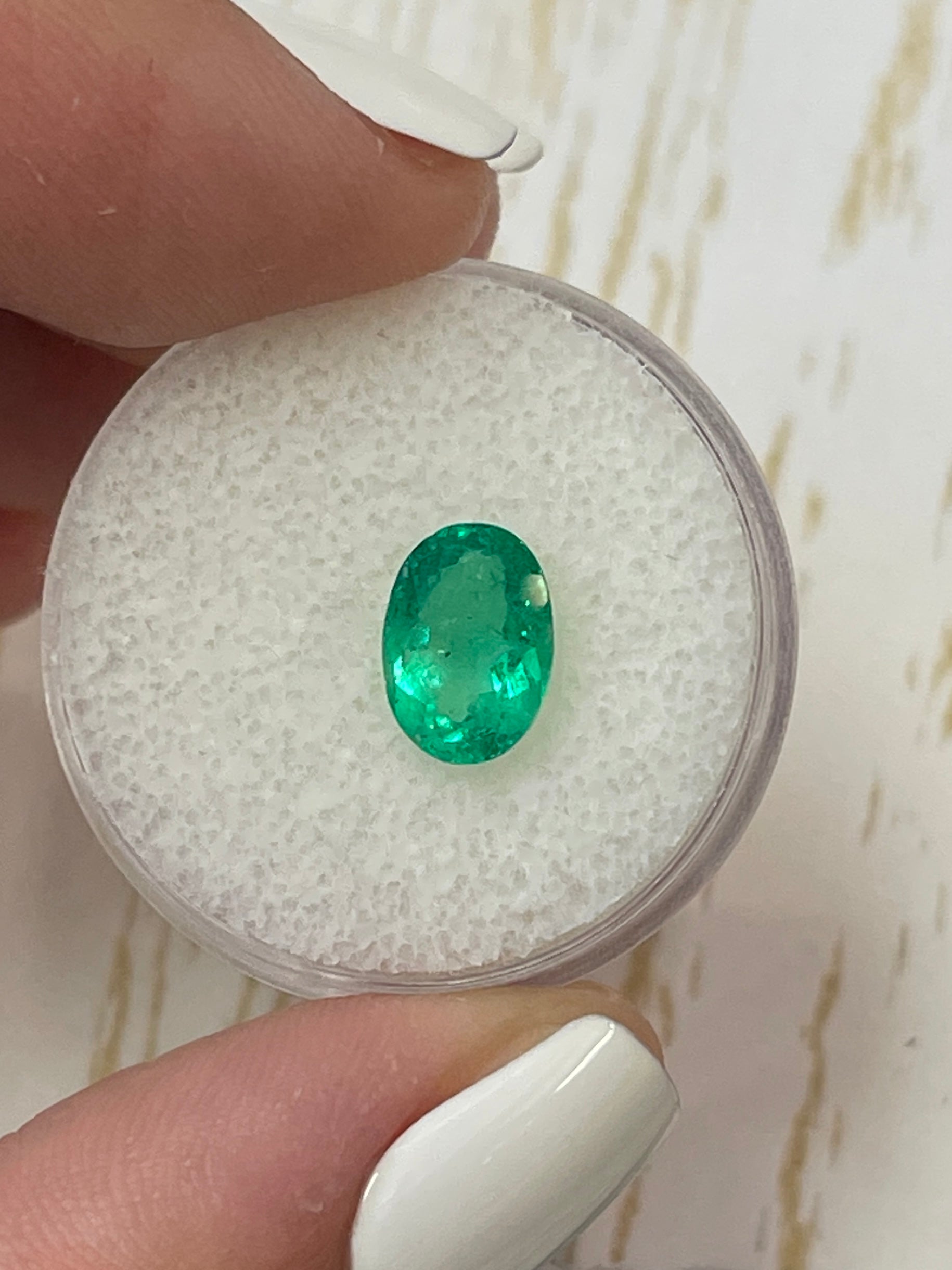 Medium yellowish green 1.69 carat Colombian emerald in oval cut, natural loose gemstone from JR Colombian Emeralds.