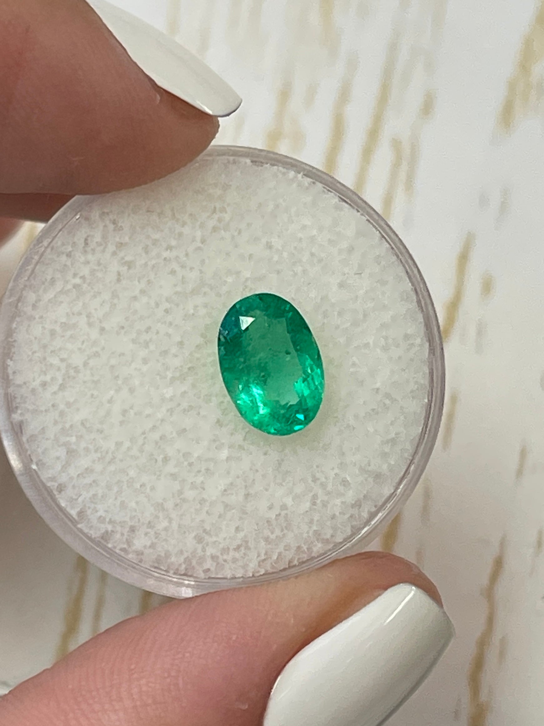 Oval cut 1.69 carat medium yellowish green Colombian emerald loose gemstone by JR Colombian Emeralds.