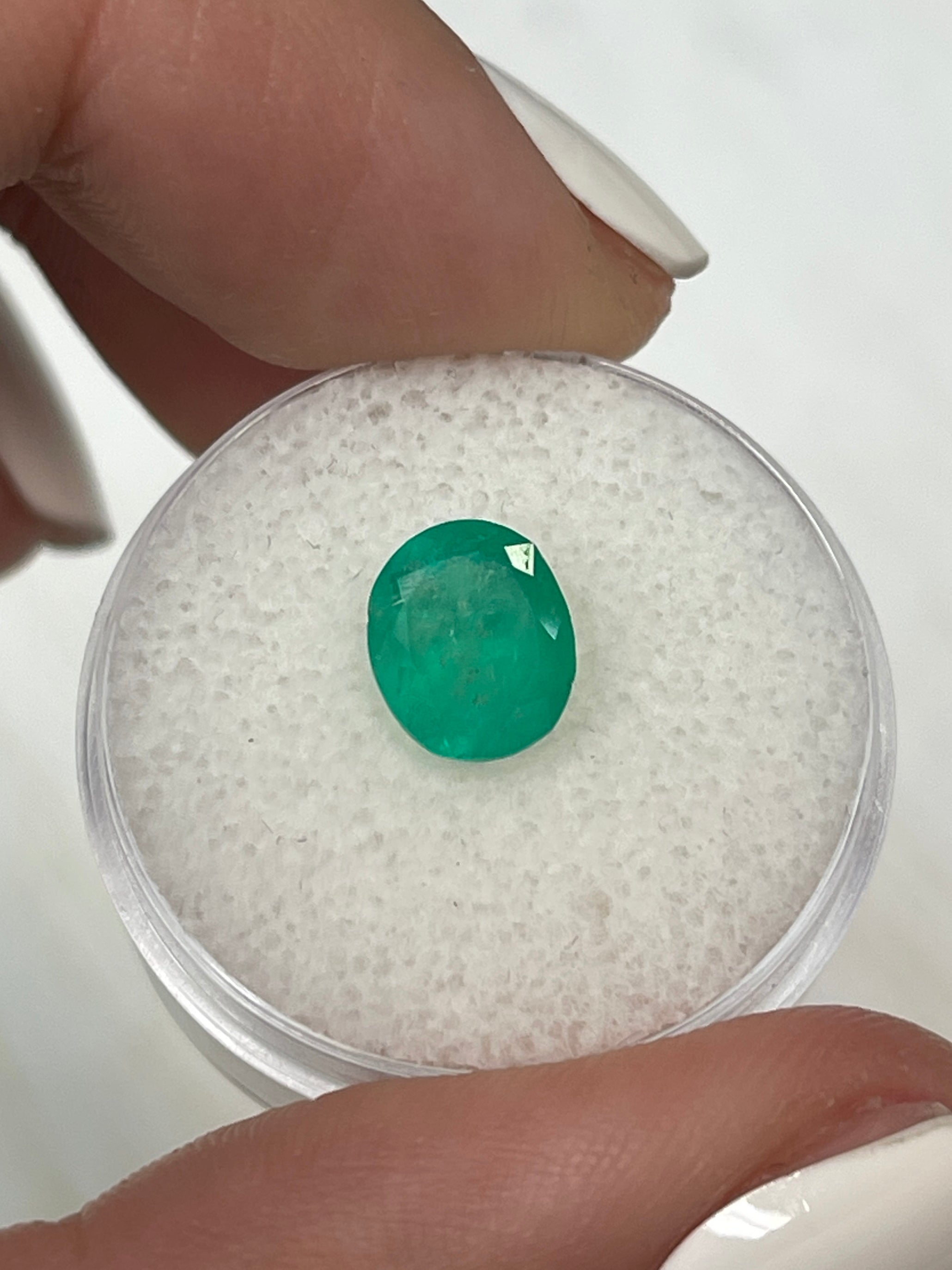 Loose 1.76 carat oval-cut Colombian emerald from JR Colombian Emeralds, showcasing vibrant medium green natural gemstone.