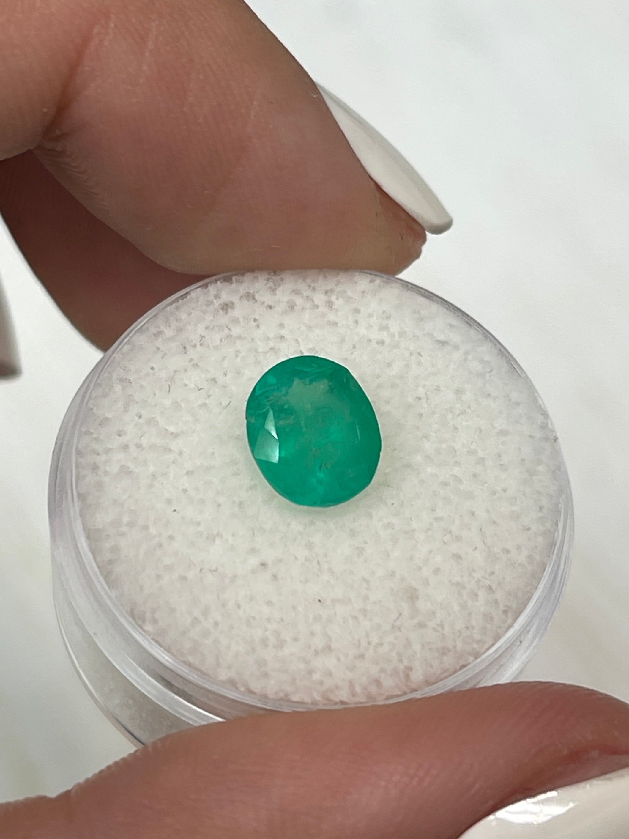 Natural 1.76 carat oval cut Colombian emerald gemstone from JR Colombian Emeralds, showcasing vibrant green color and chunky medium size.
