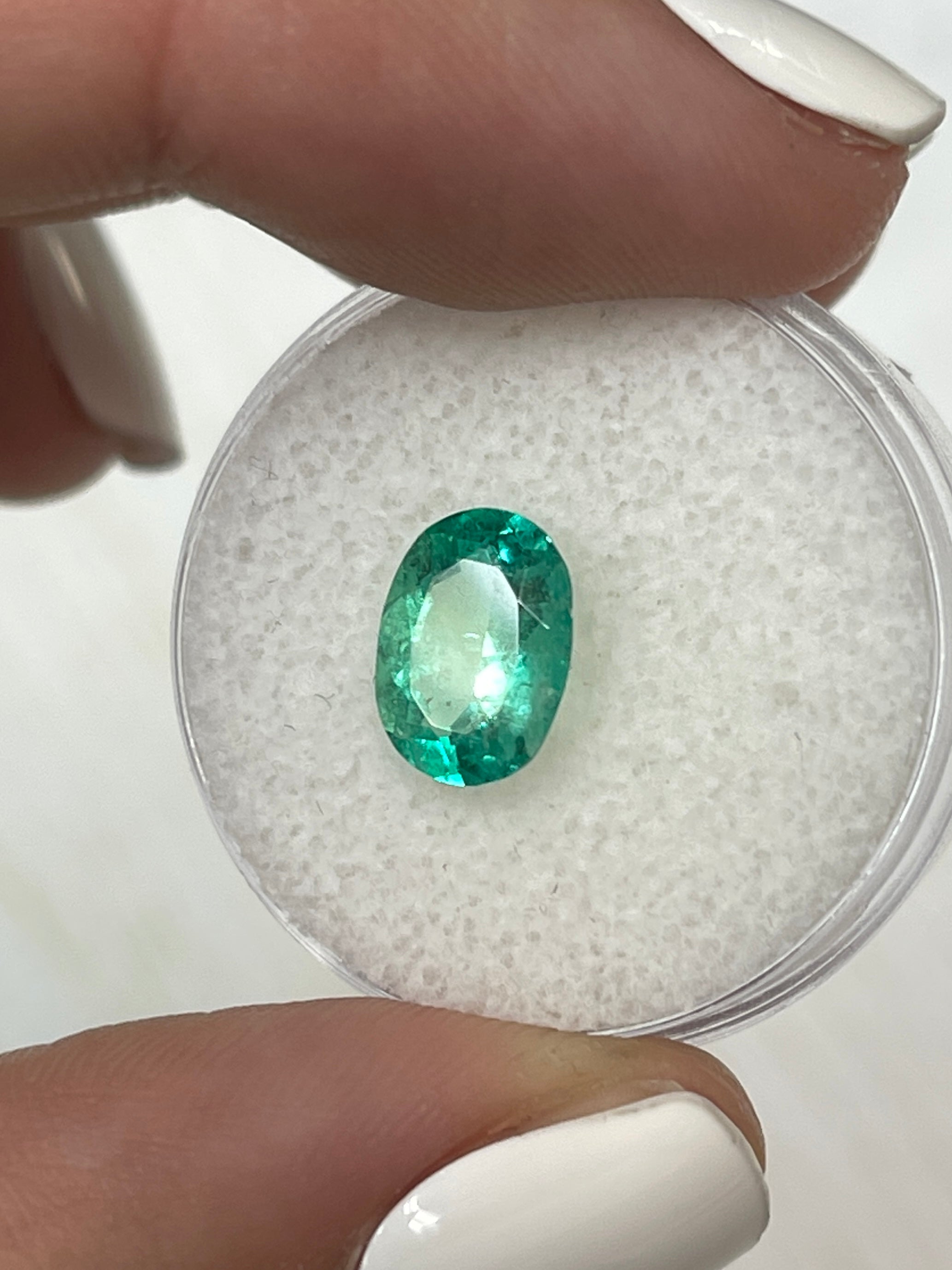 Loose 1.77 carat medium-light green Colombian emerald in oval cut, natural, with a polished surface, by JR Colombian Emeralds.
