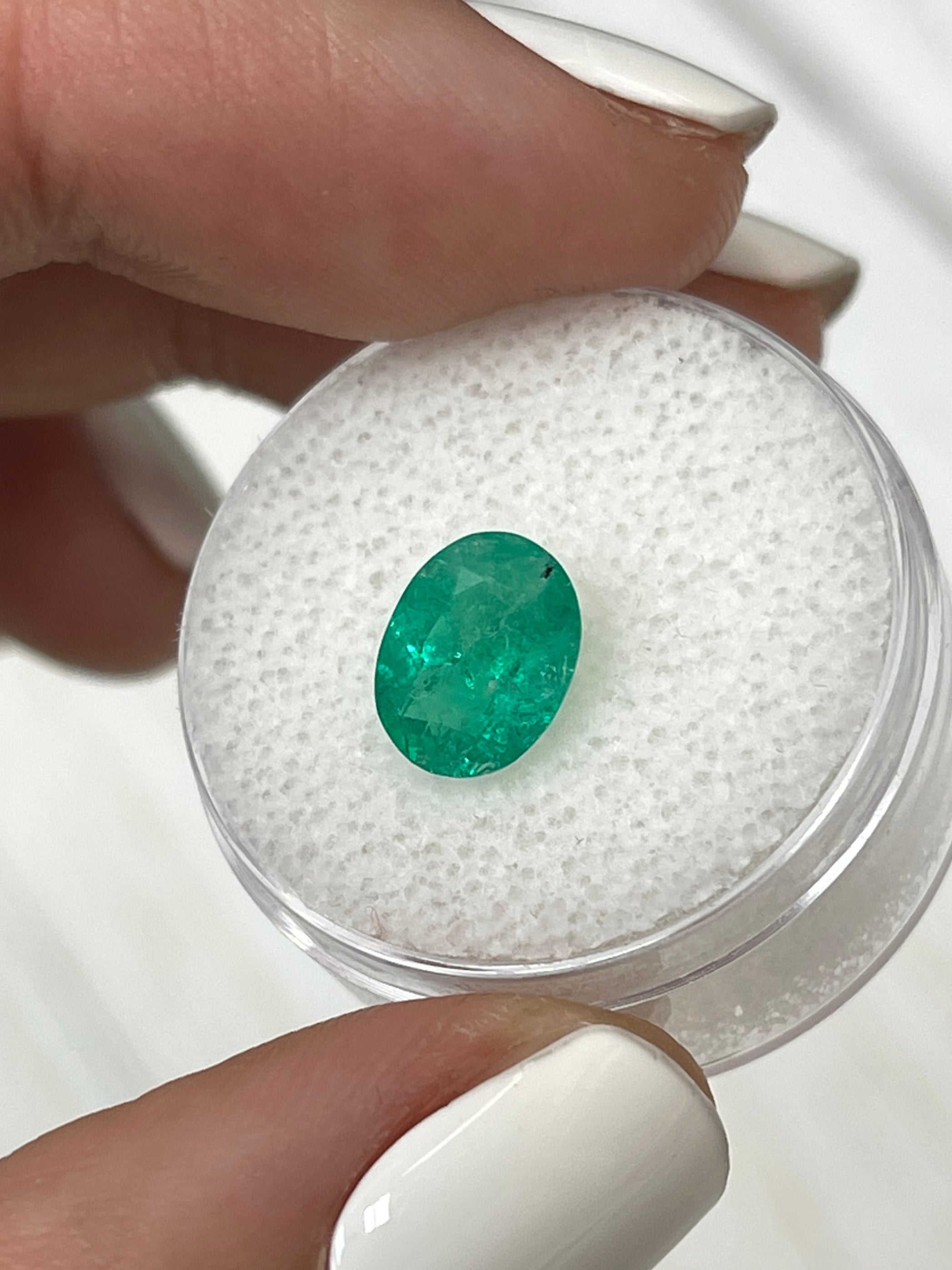 Loose 1.87 Carat medium green Colombian emerald in oval cut, natural gemstone with rich green color and polished surface.