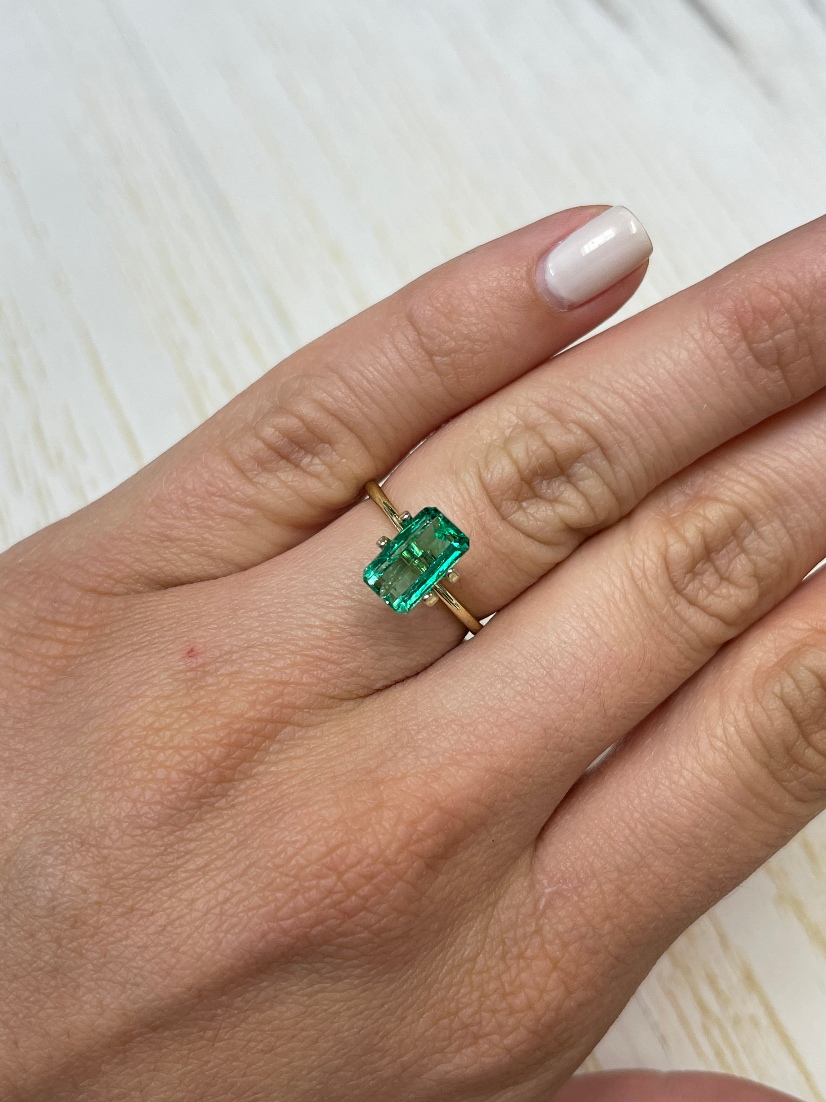Loose 2.38 carat Muzo green Colombian emerald in an emerald cut, featuring a slender 10x6 mm shape from JR Colombian Emeralds.