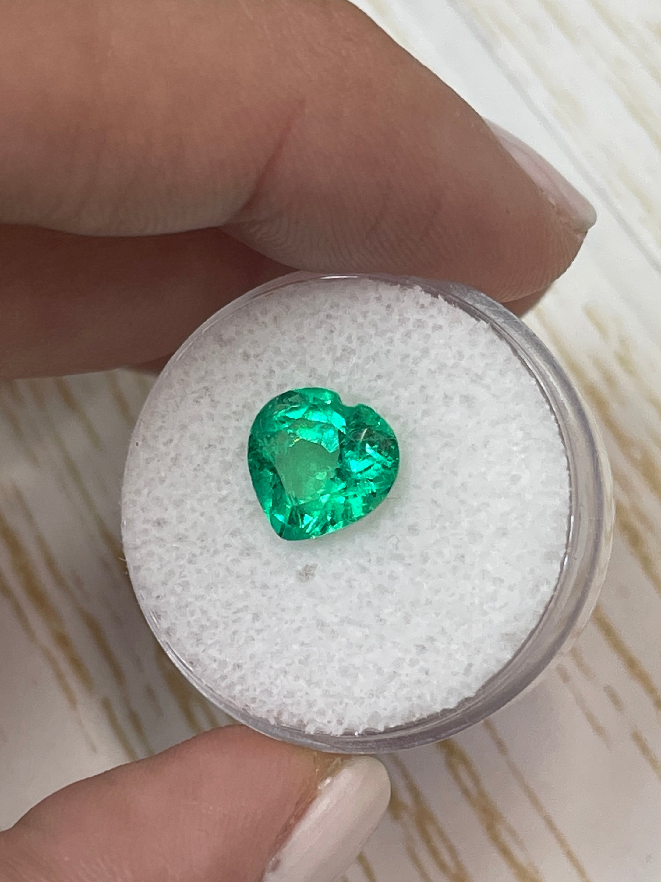2.45 carat yellowish green natural Colombian emerald loose heart cut gemstone, showcasing vibrant color and clarity.