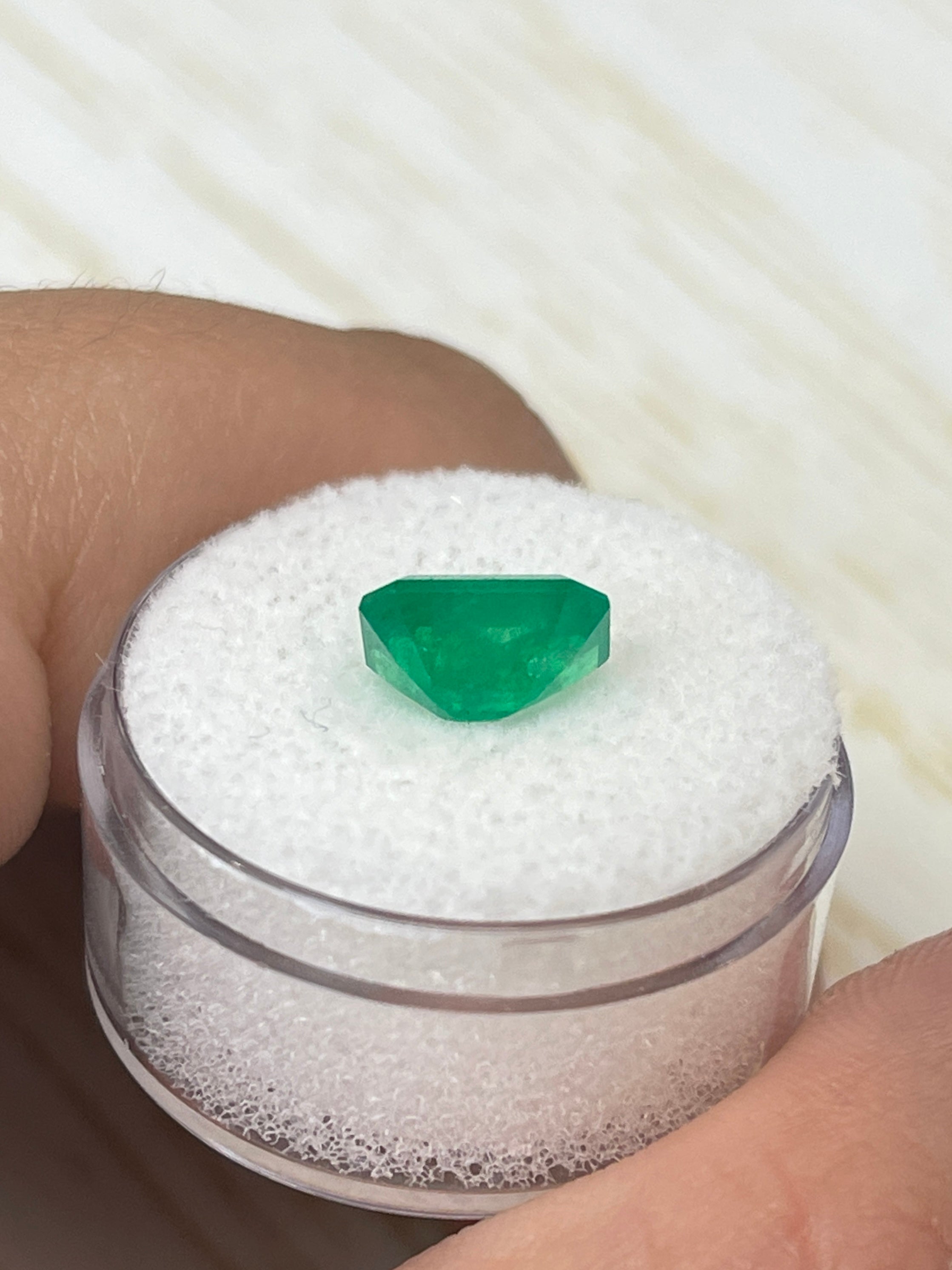 2.52 Carat intense green natural Colombian emerald loose gemstone in an emerald cut, displayed on a neutral background.