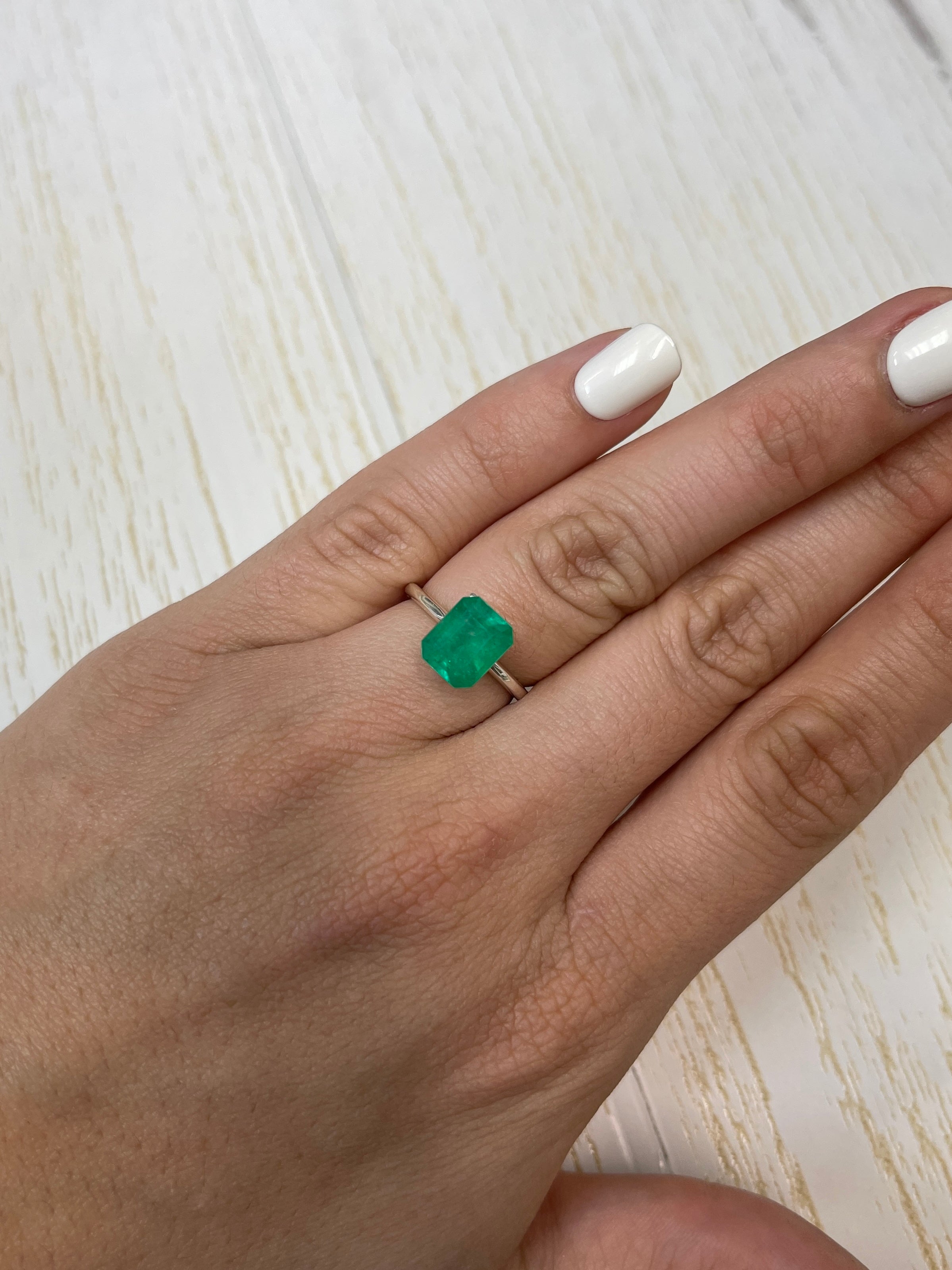 2.52 carat intense green natural Colombian emerald loose gemstone with emerald cut, displayed on a white background.