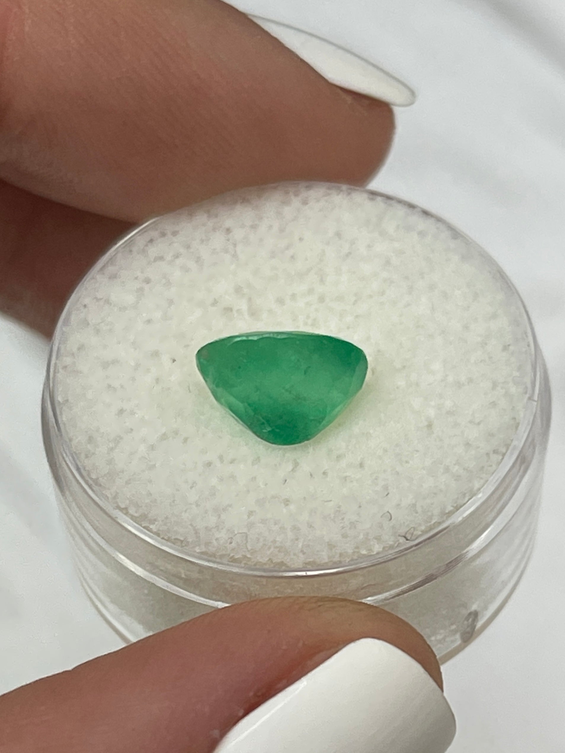 2.52 carat mossy yellowish green natural Colombian emerald loose oval cut gemstone with rich color and unique texture.