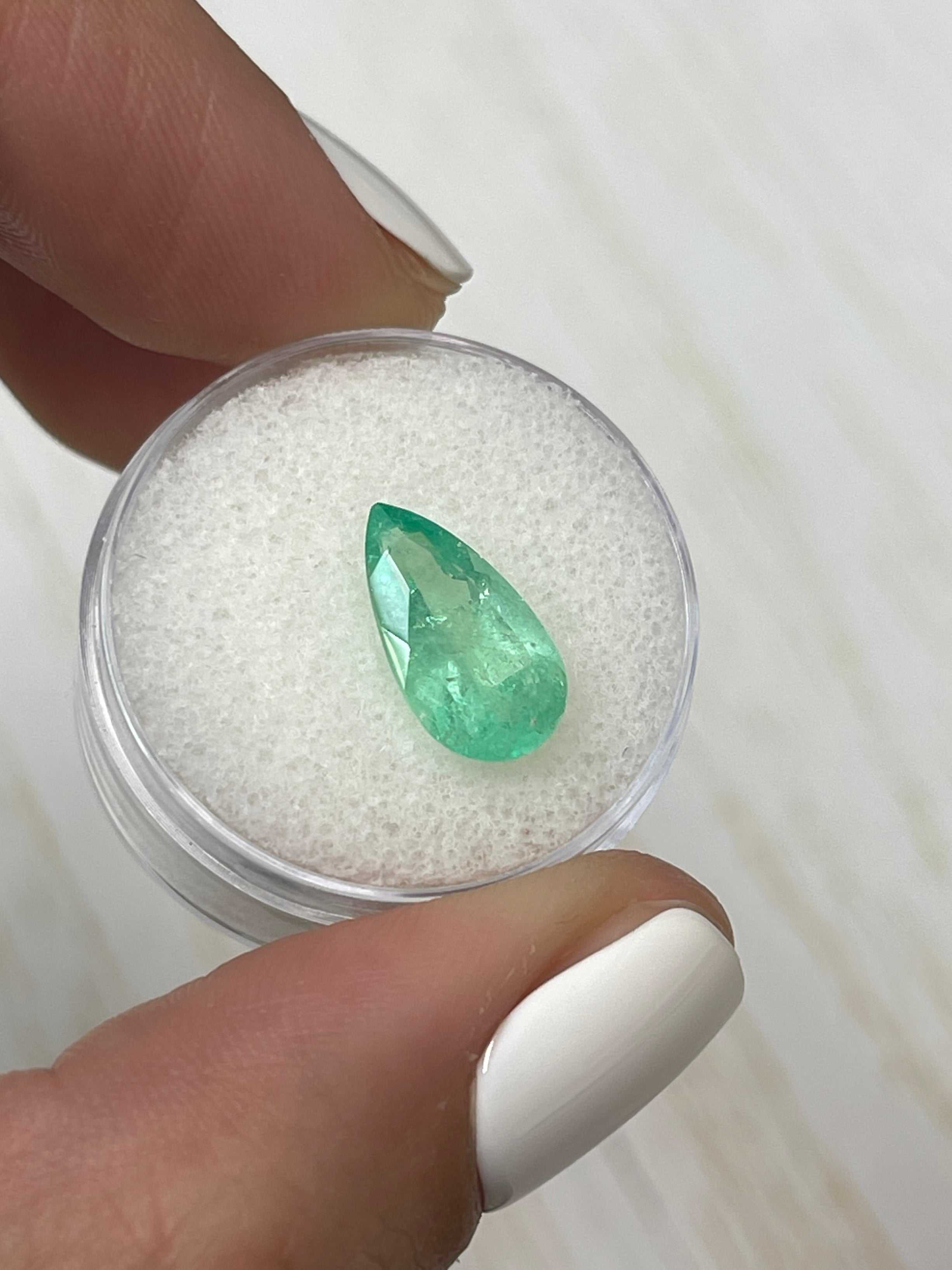 2.76 carat elongated green Colombian emerald in pear cut, showcasing vibrant color and clarity on a neutral background.