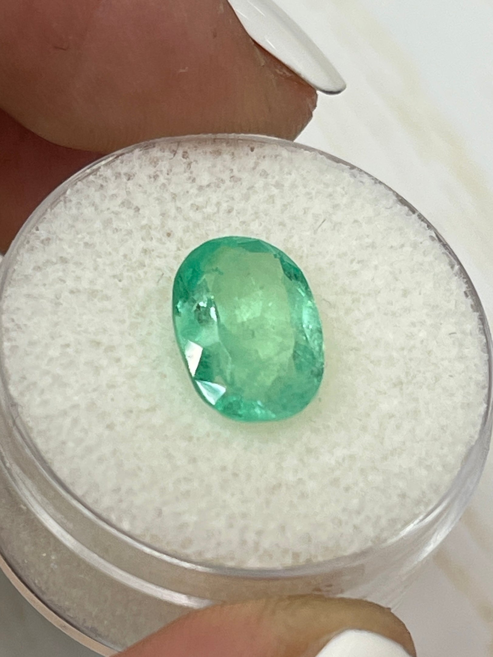 Light yellowish green 2.78 carat natural Colombian emerald in oval cut, showcasing vibrant color and clarity.