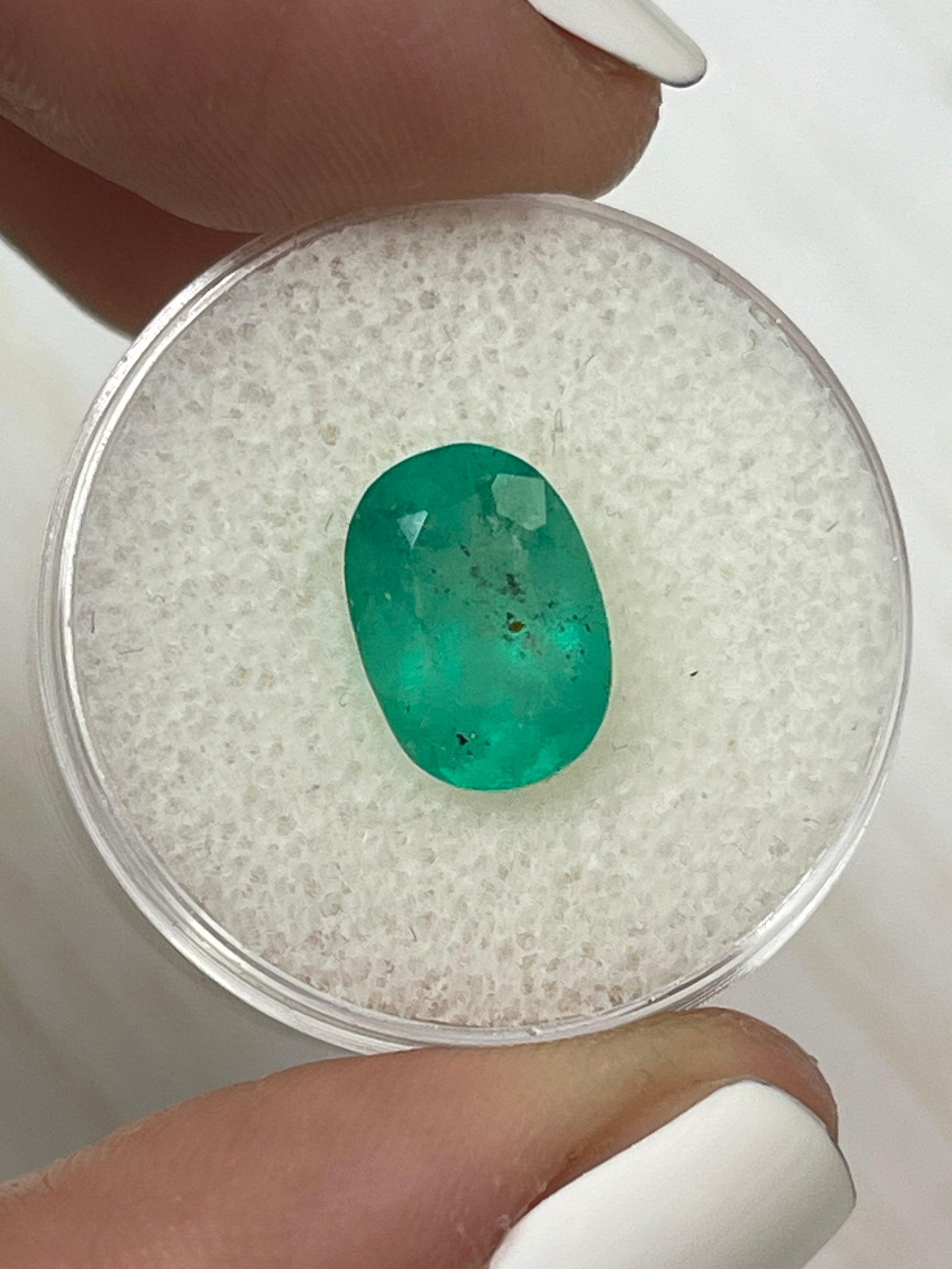 Medium green Colombian emerald loose gemstone, 2.95 carats, oval cut with natural freckles, from JR Colombian Emeralds.