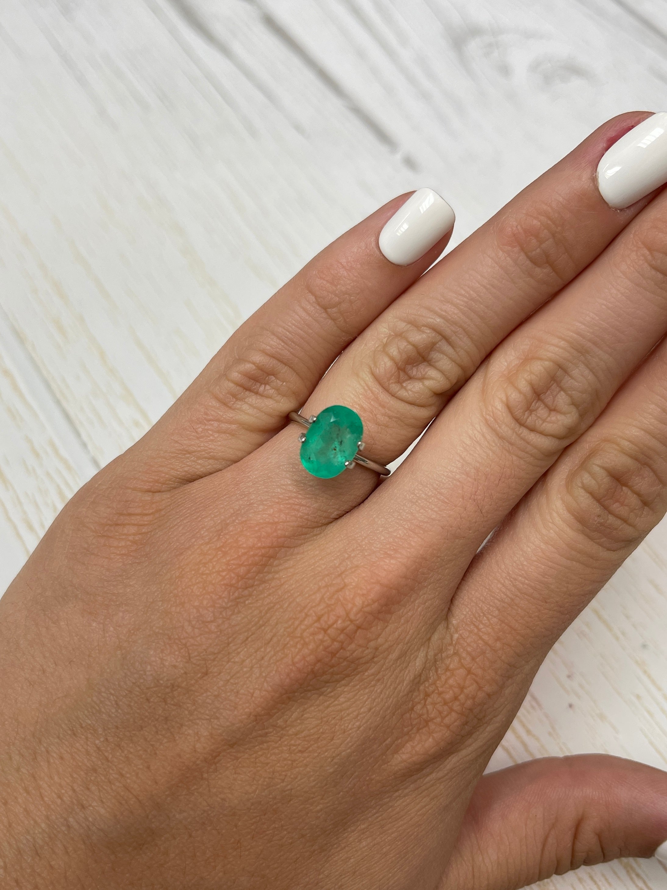 2.95 carat medium green Colombian emerald loose oval cut with natural freckles from JR Colombian Emeralds.