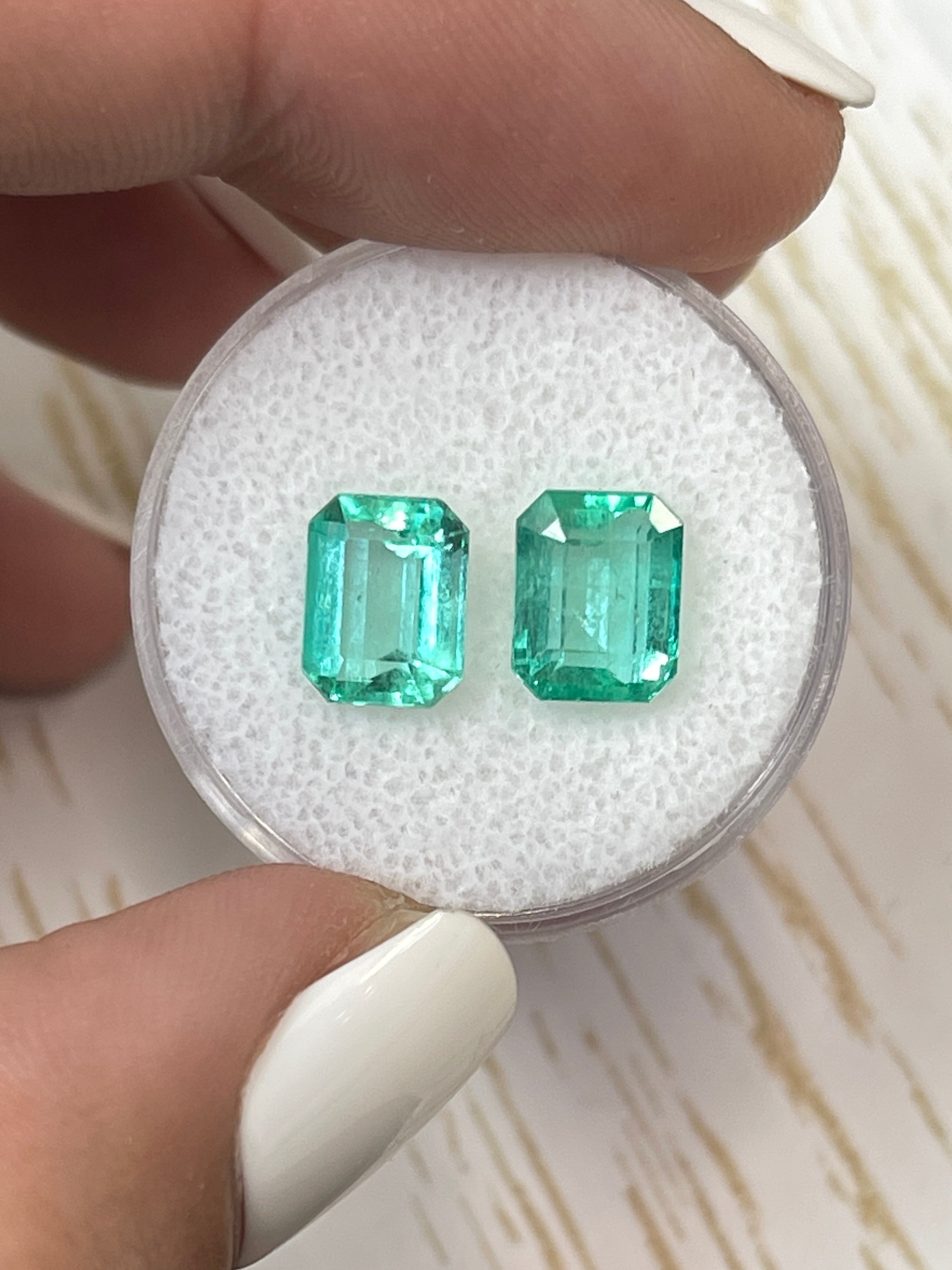 Matching 3.03tcw Colombian emeralds in an 8x6 emerald cut, showcasing vibrant green loose gemstones by JR Colombian Emeralds.