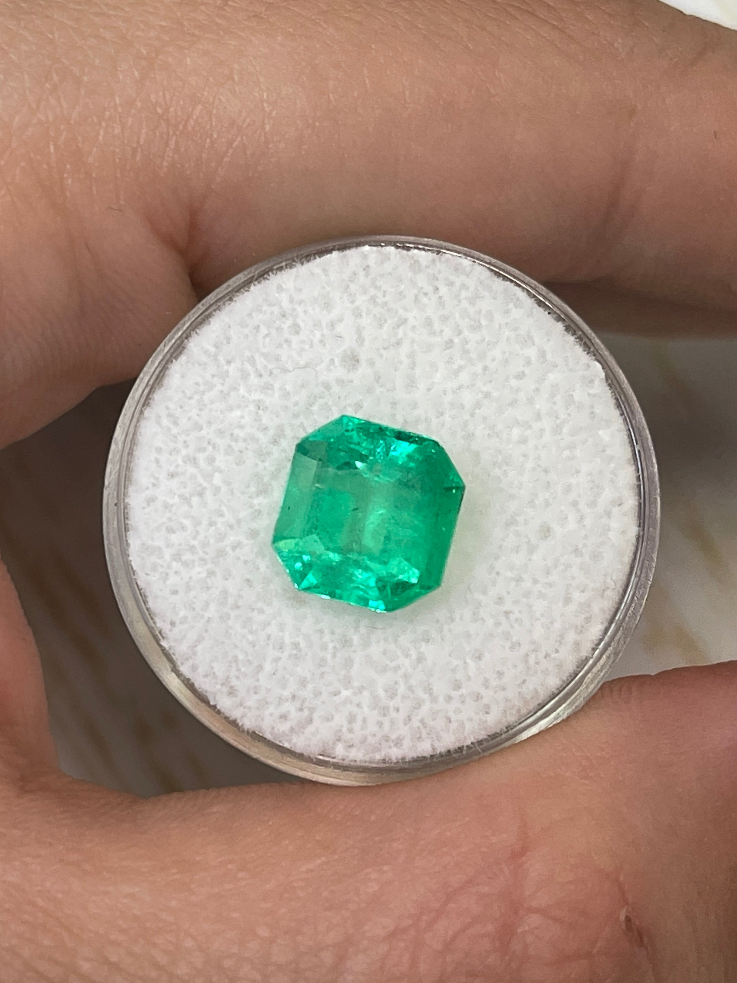 3.21 carat yellowish green natural Colombian emerald loose Asscher cut gemstone with visible facets and rich color.
