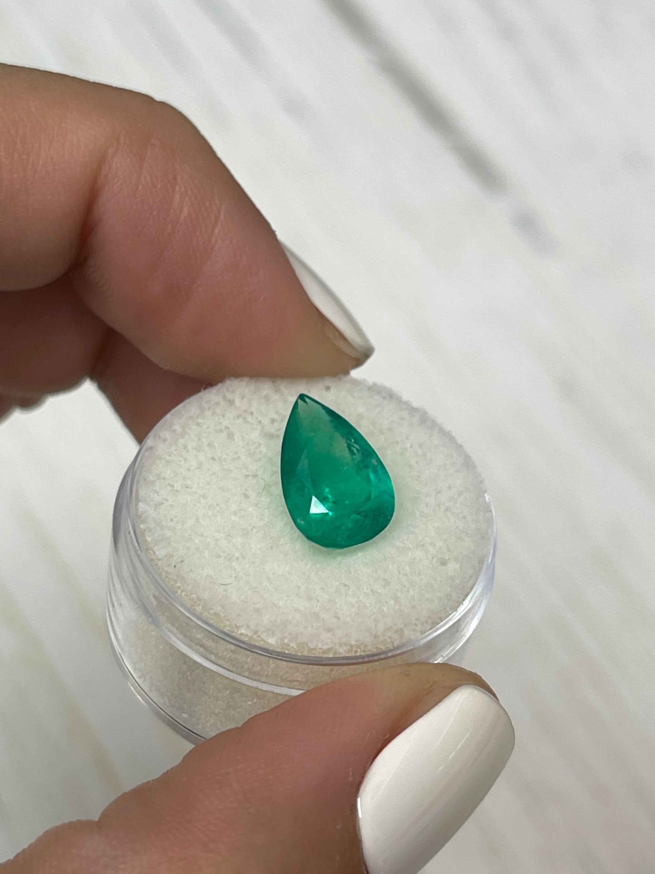 Natural 3.46 carat grass green Colombian emerald pear cut loose gemstone by JR Colombian Emeralds on a white background.