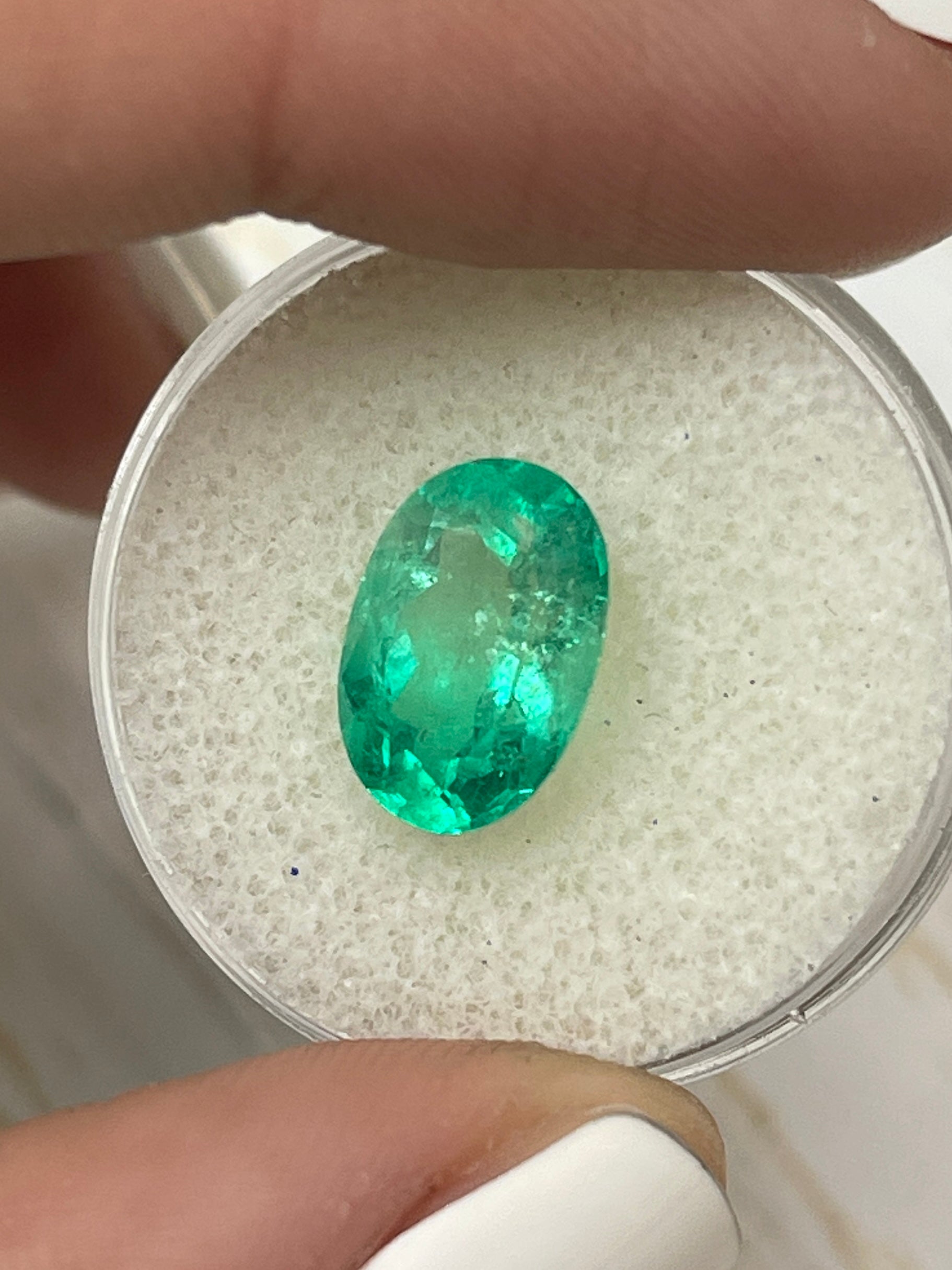 3.56 carat bi-color green natural Colombian emerald loose oval cut gemstone showcasing vibrant green hues and clarity.