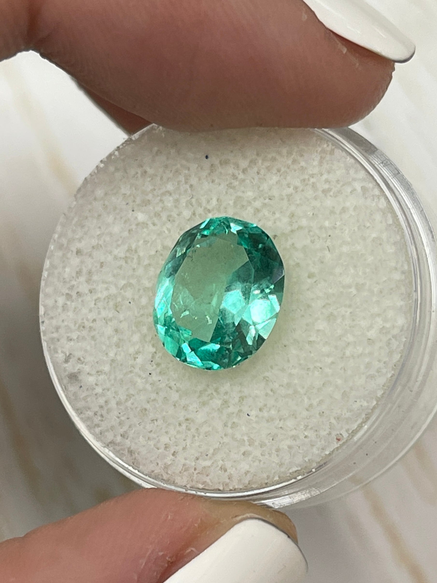 Oval cut 3.70 carat green Colombian emerald loose gemstone with VS clarity, shown in a detailed close-up image.