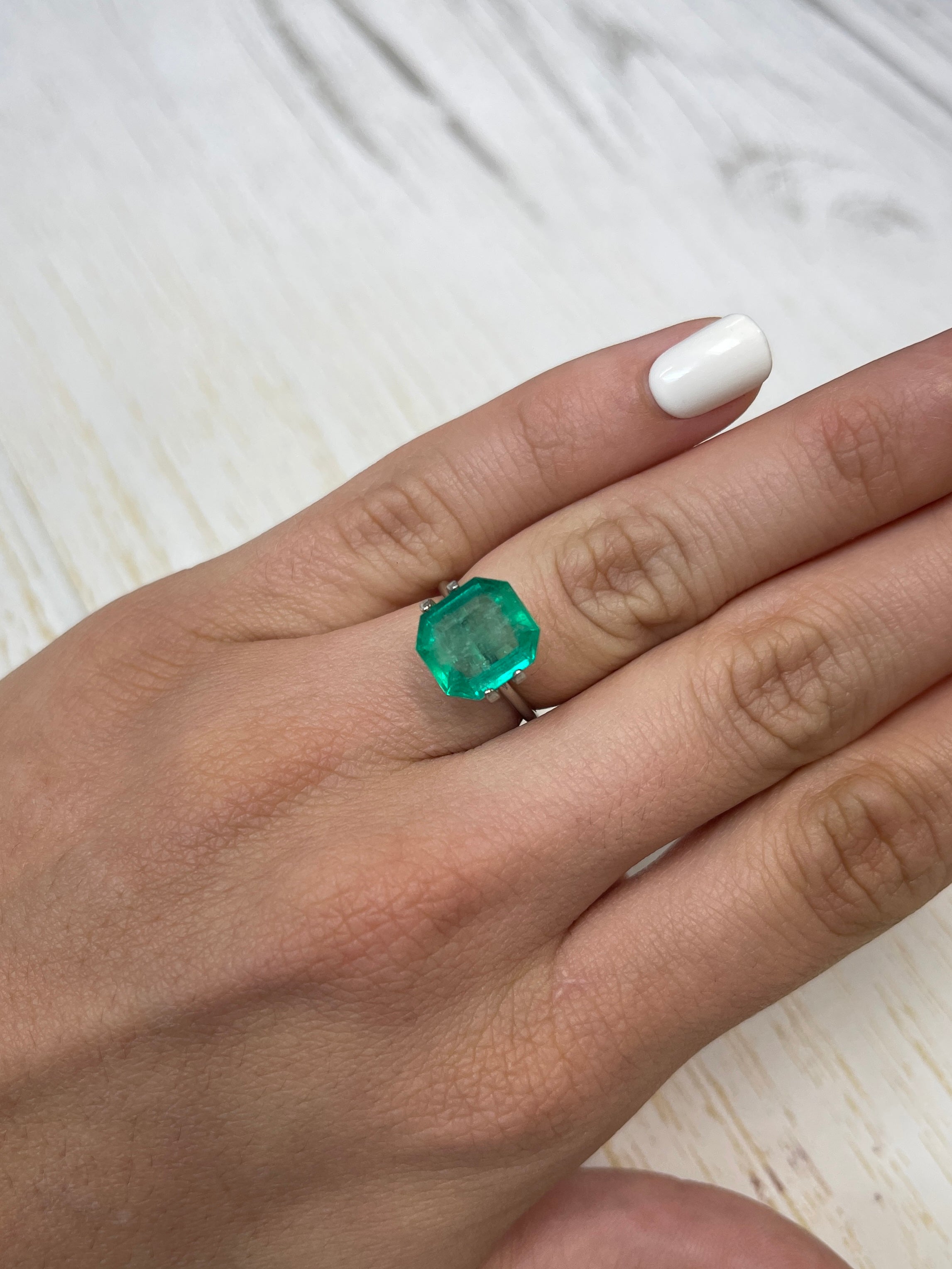 Natural 4.56 carat Colombian emerald loose stone, 11x10mm emerald cut, showcasing vibrant green color and clarity.