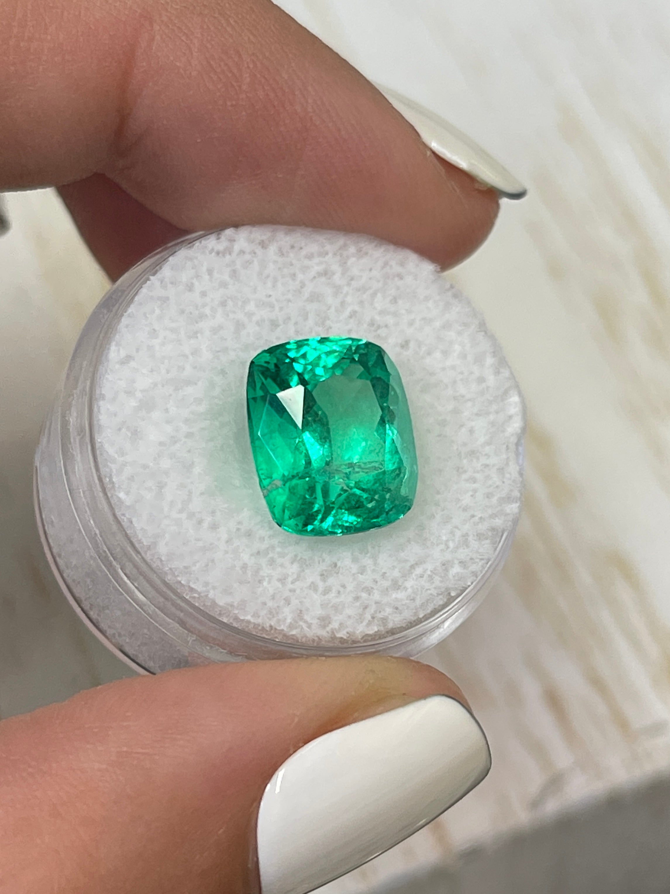 Natural 12x10.4 mm cushion cut Colombian emerald loose gemstone with minor to moderate oil, intense green color, from JR Colombian Emeralds.