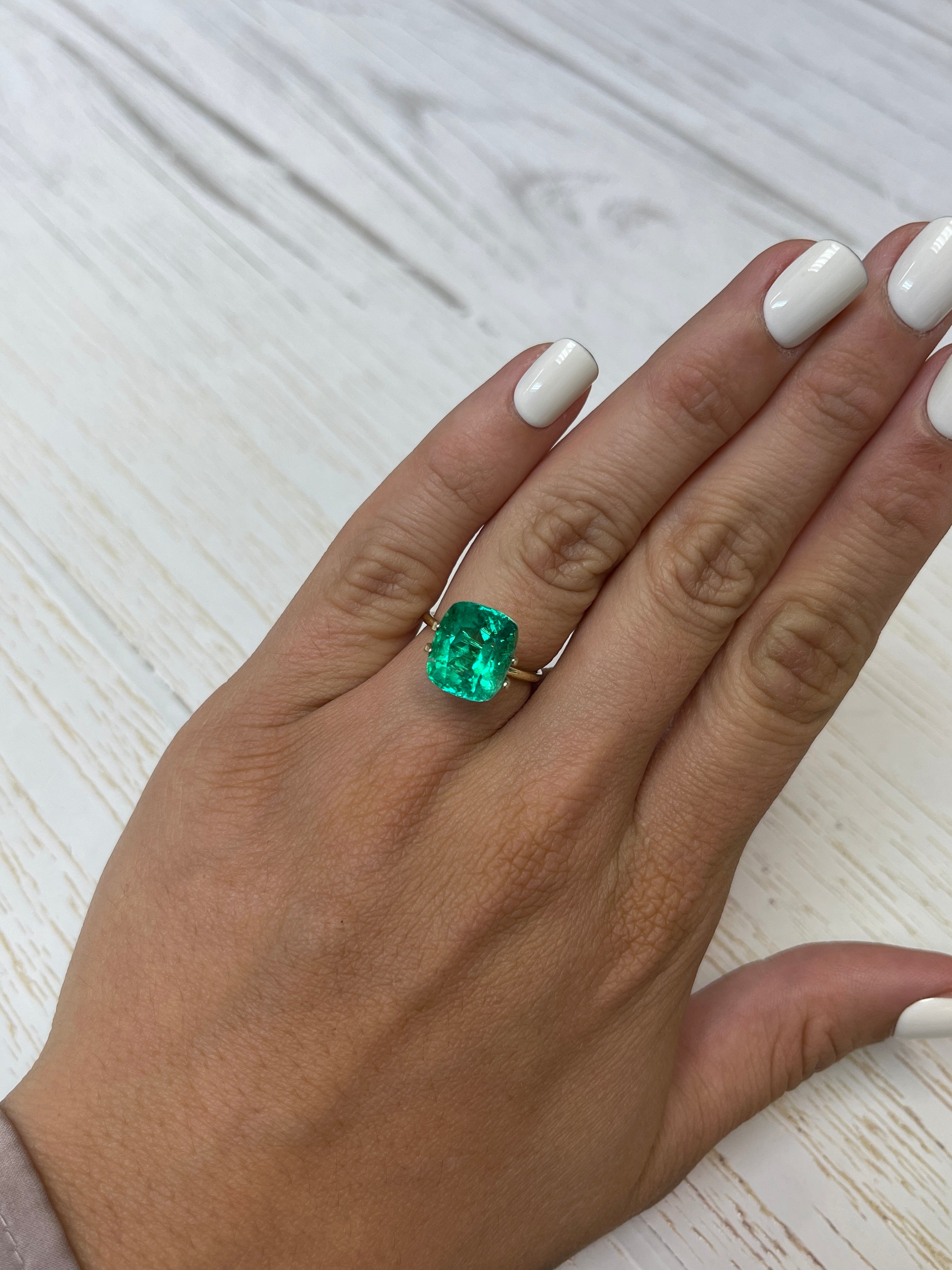 Natural 12x10.4 mm cushion cut Colombian emerald loose gemstone with intense green color, 6.17 carats, minor to moderate oil treatment.