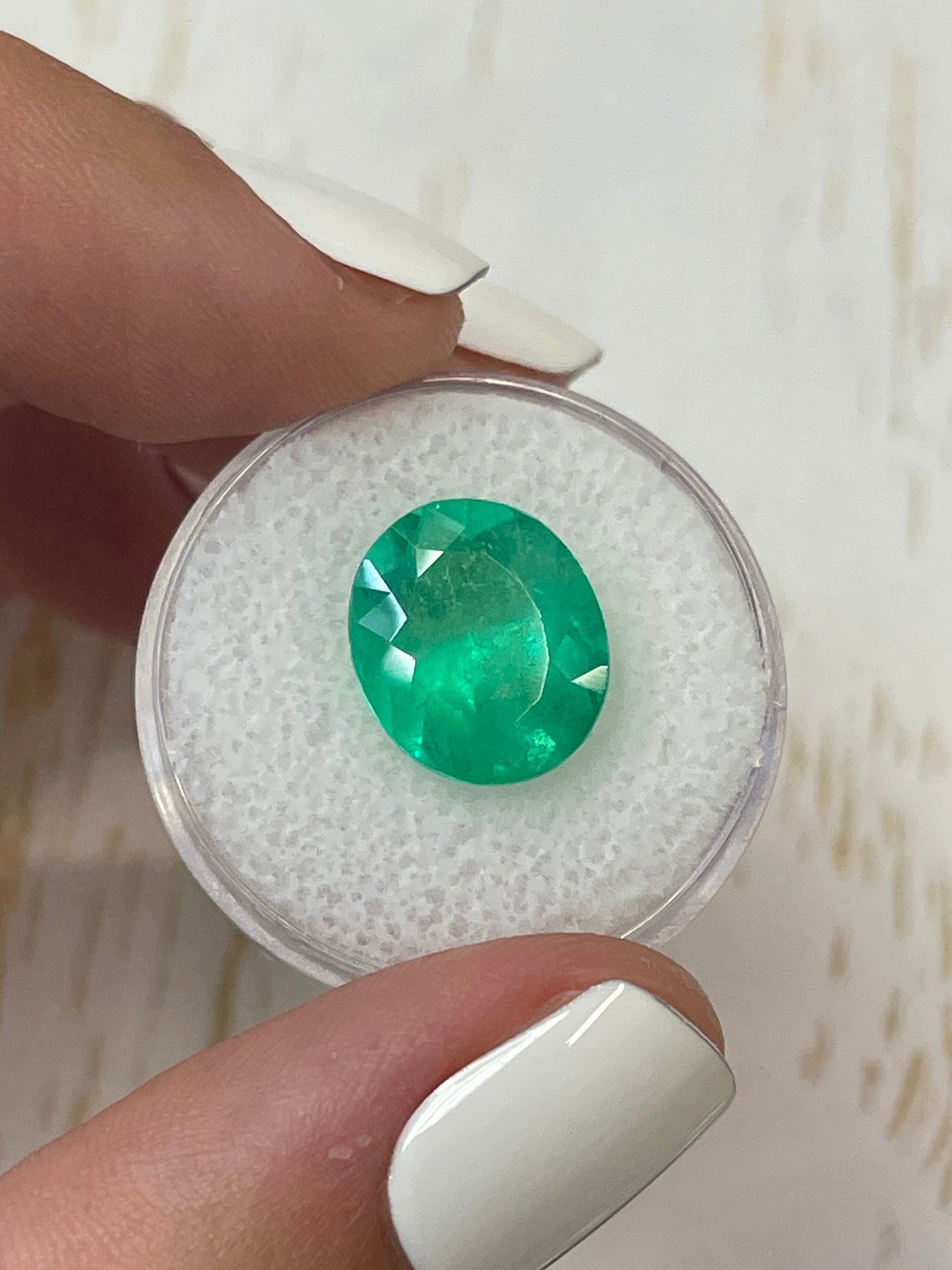Neon green 6.35 carat oval cut Colombian emerald from JR Colombian Emeralds, natural loose gemstone with vibrant color.