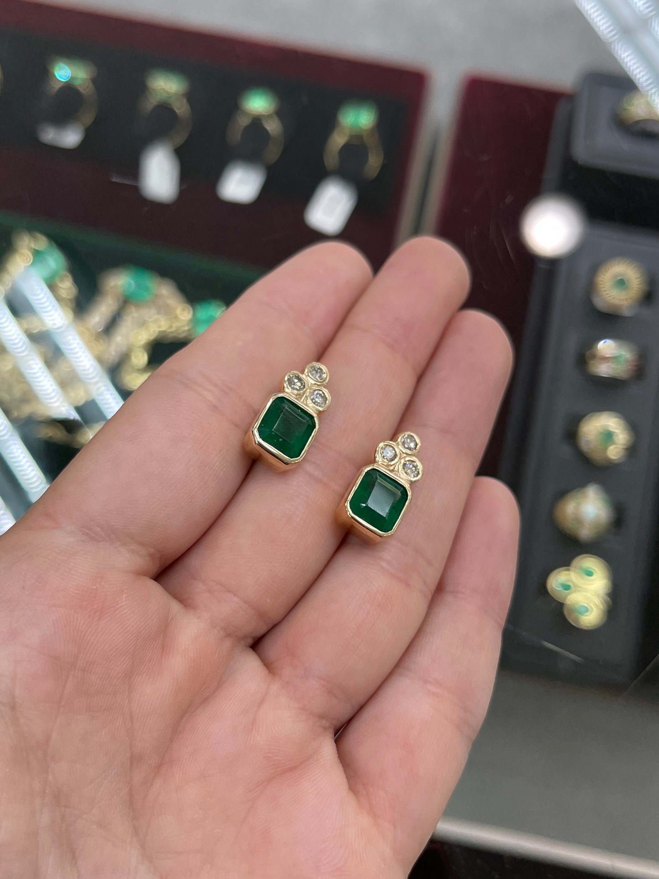 Dark forest green emerald-cut earrings with diamond accents in 14K gold, featuring natural emeralds by JR Colombian Emeralds.