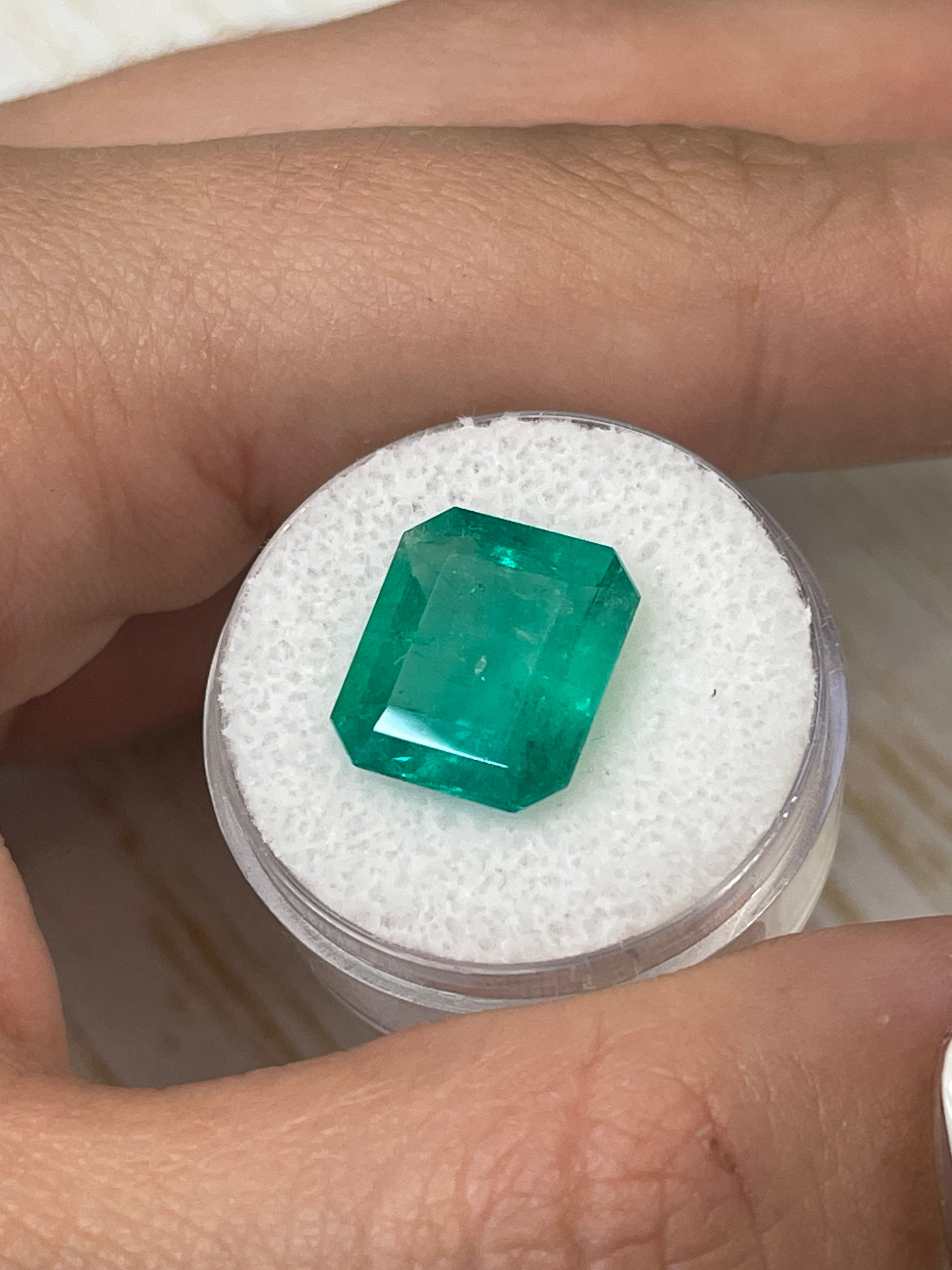 7.39-carat bluish-green Colombian emerald cut loose gemstone from JR Colombian Emeralds, showing its rectangular shape and vibrant color.