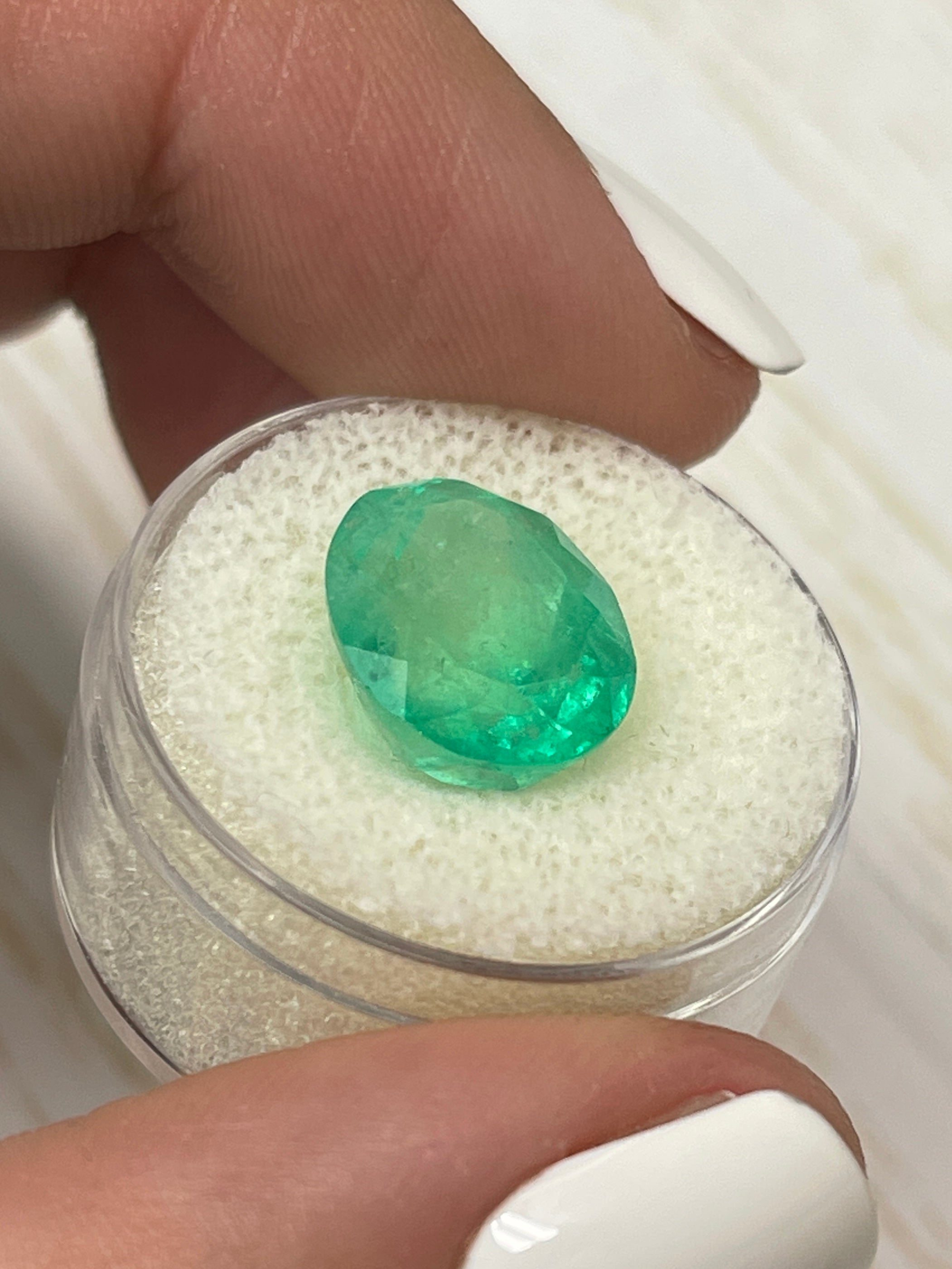 7.80 carat medium yellowish green natural Colombian emerald in oval cut, showcasing vibrant color and clarity.