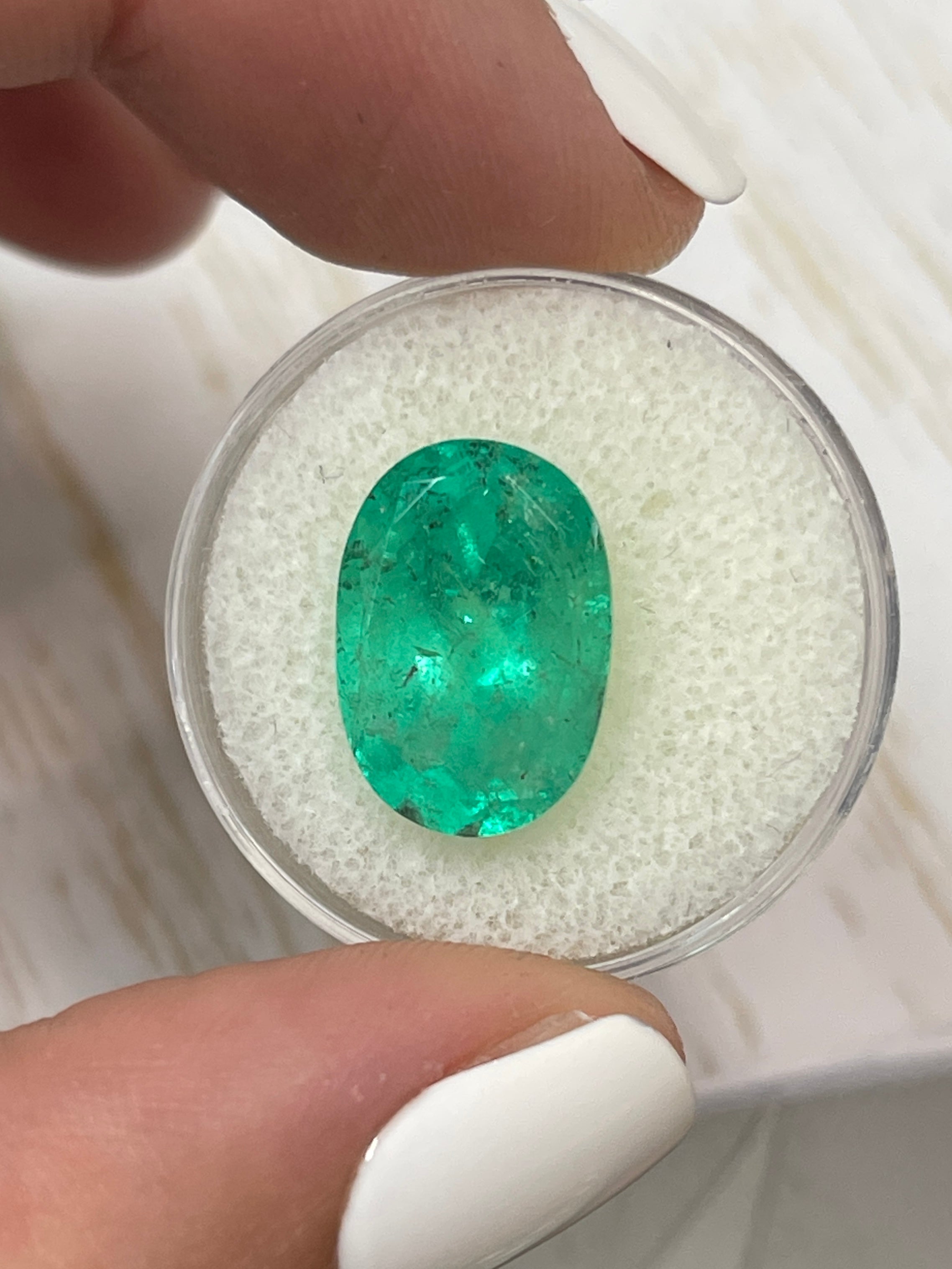 8.64 carat freckled medium green Colombian emerald in oval cut, natural loose gemstone, from JR Colombian Emeralds.