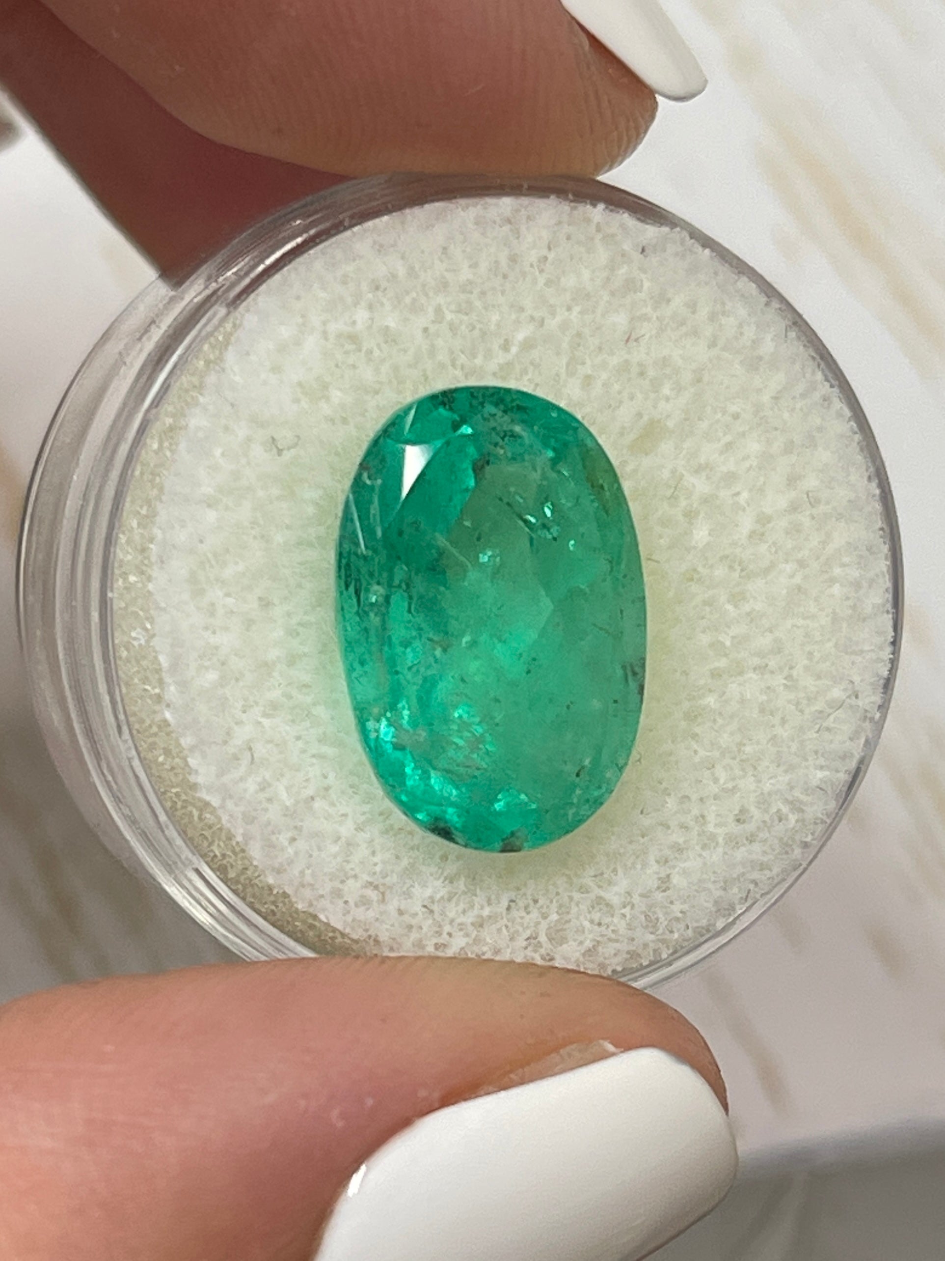 8.64 carat freckled medium green Colombian emerald loose oval cut gemstone by JR Colombian Emeralds.