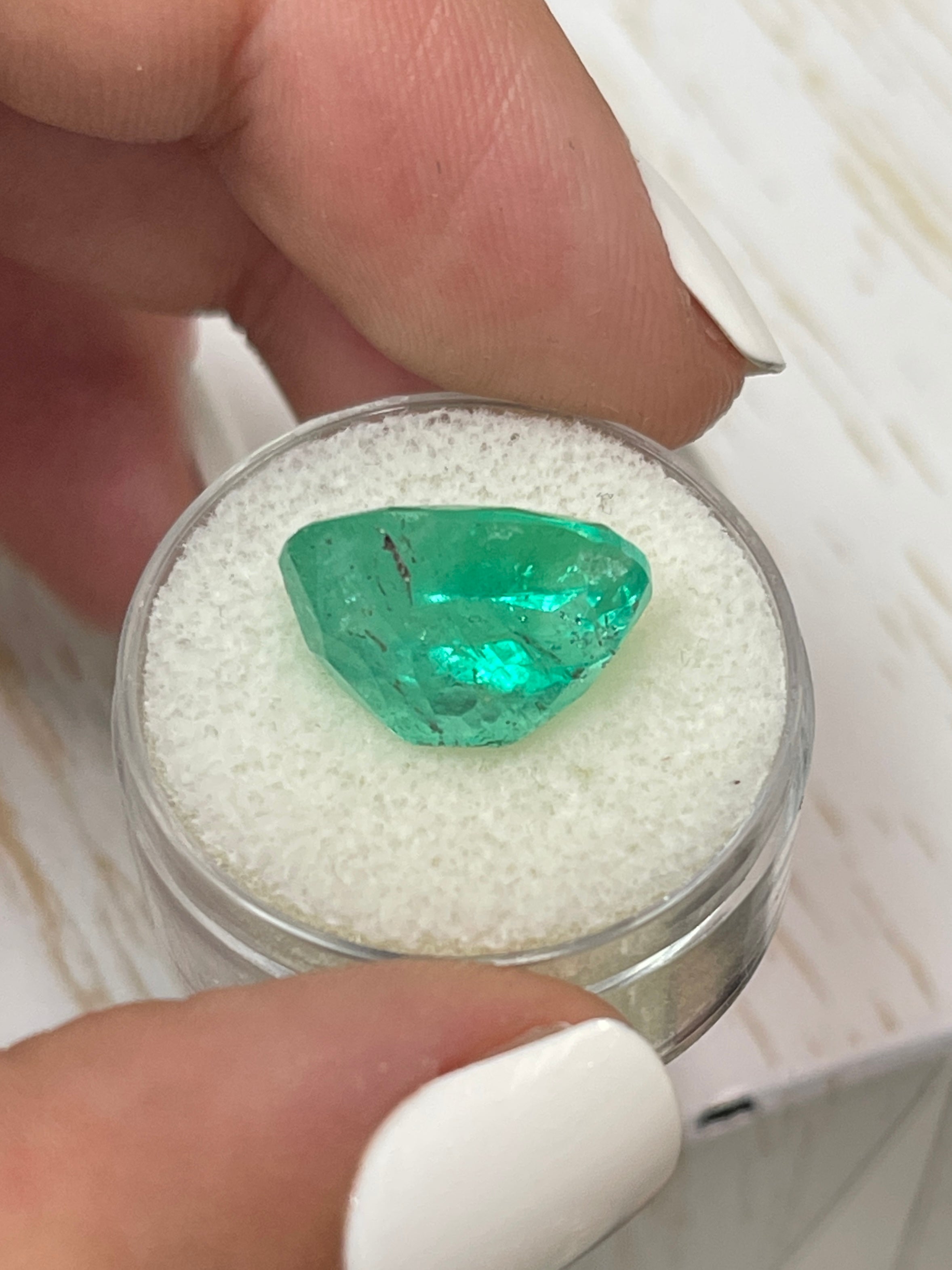 8.64 carat freckled medium green Colombian emerald loose oval cut gemstone from JR Colombian Emeralds.