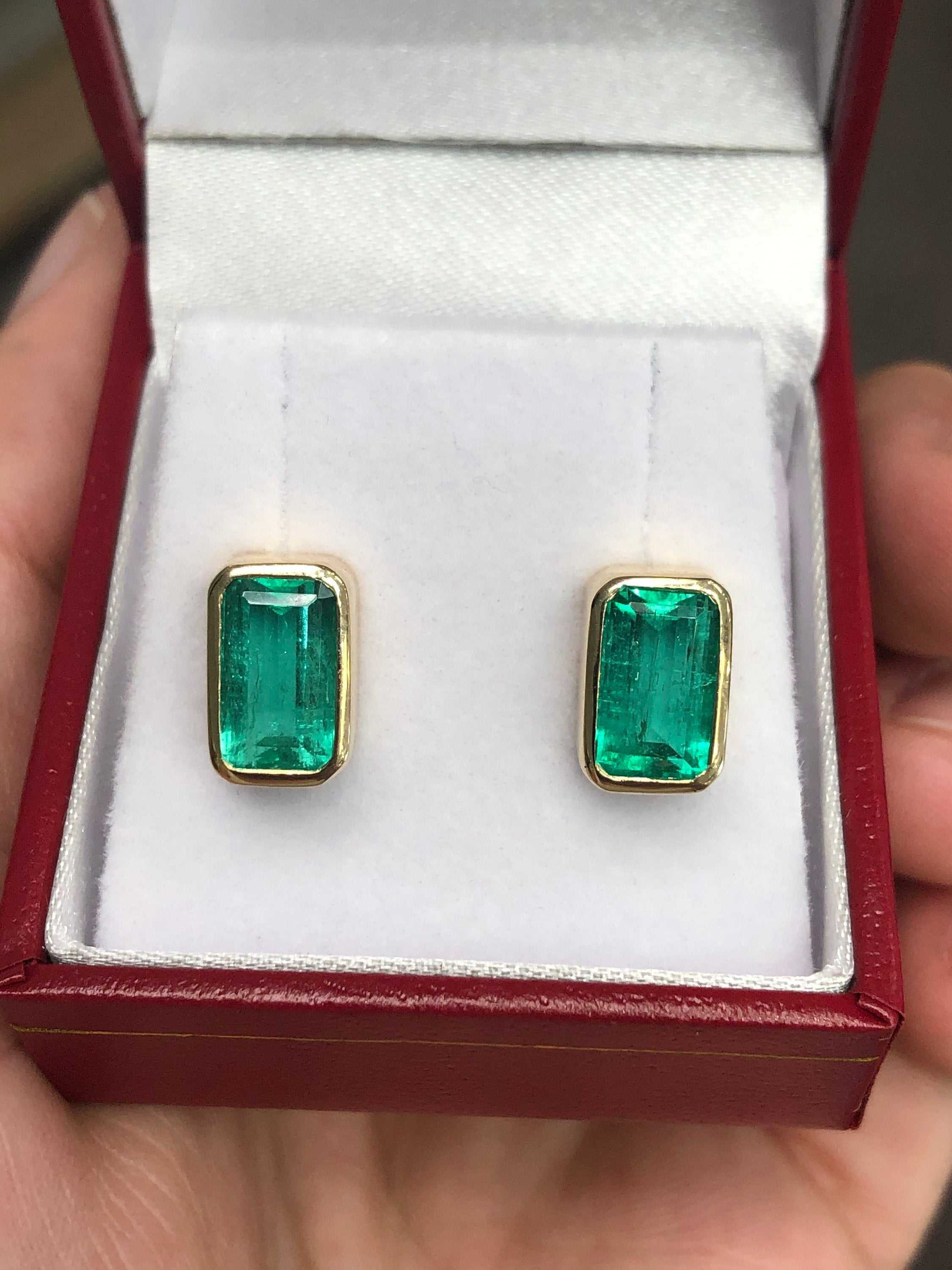 High-quality emerald cut Colombian emerald stud earrings featuring bezel set 4.86tcw gemstones in 14K gold.