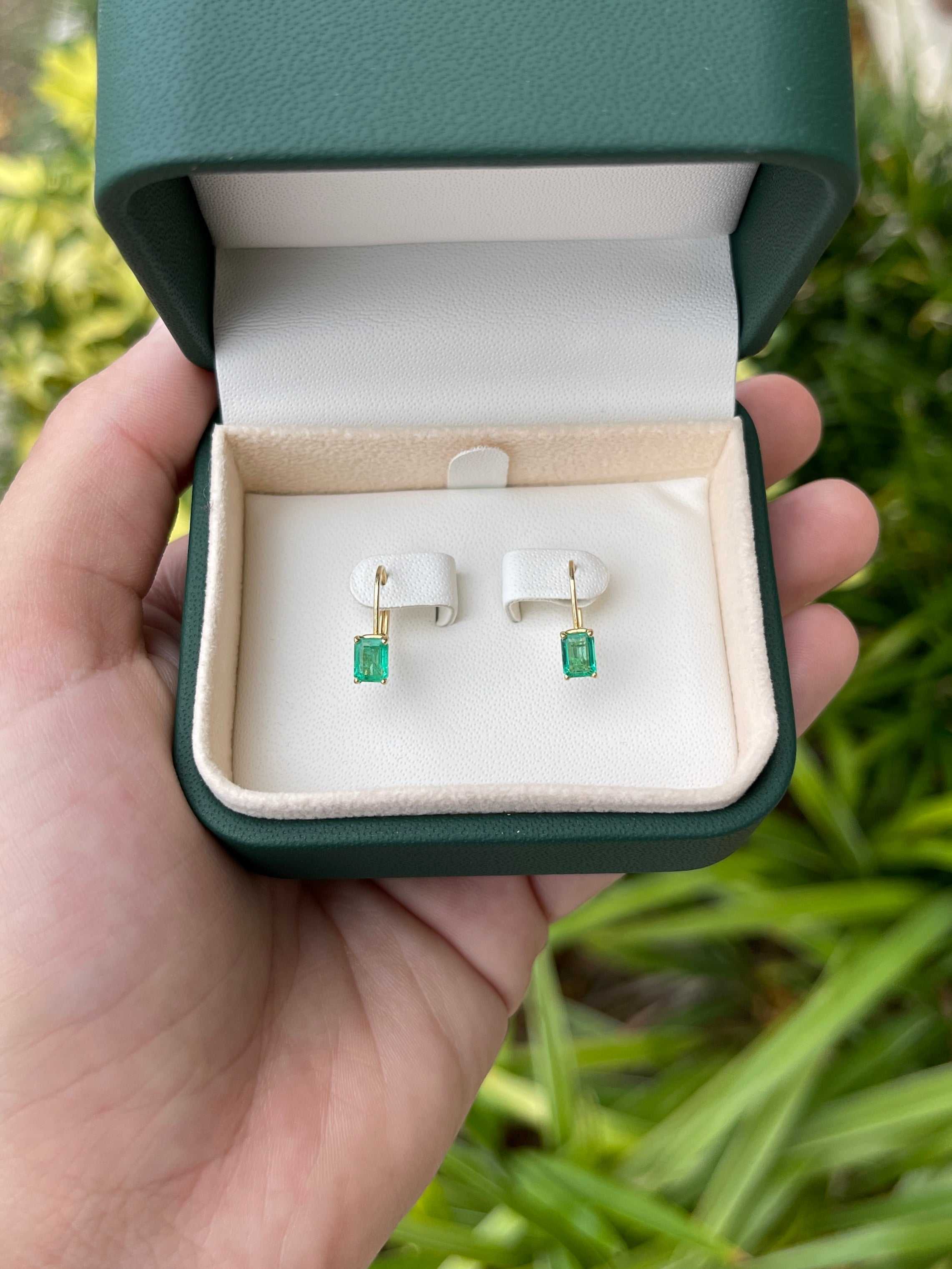 JR Colombian Emeralds 1.50tcw natural emerald cut prong set lever back earrings in 14K yellow gold.