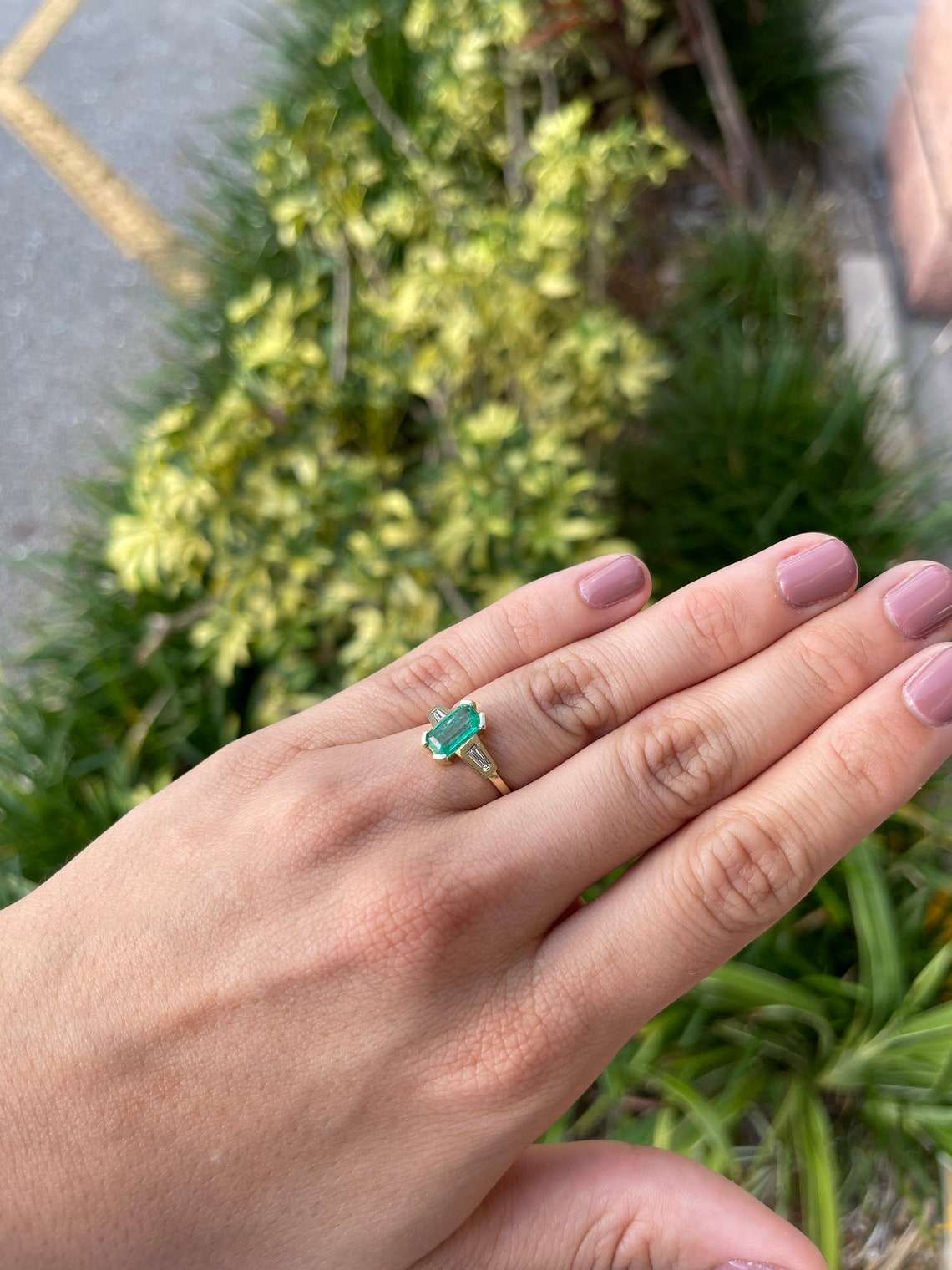 Ladies emerald ring featuring a 2.15tcw emerald cut Colombian emerald with tapered baguette diamonds in 14K gold.