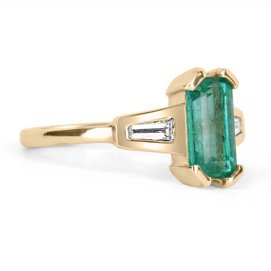Ladies emerald ring featuring a 2.15tcw emerald-cut Colombian emerald with tapered baguette diamonds in 14K gold.