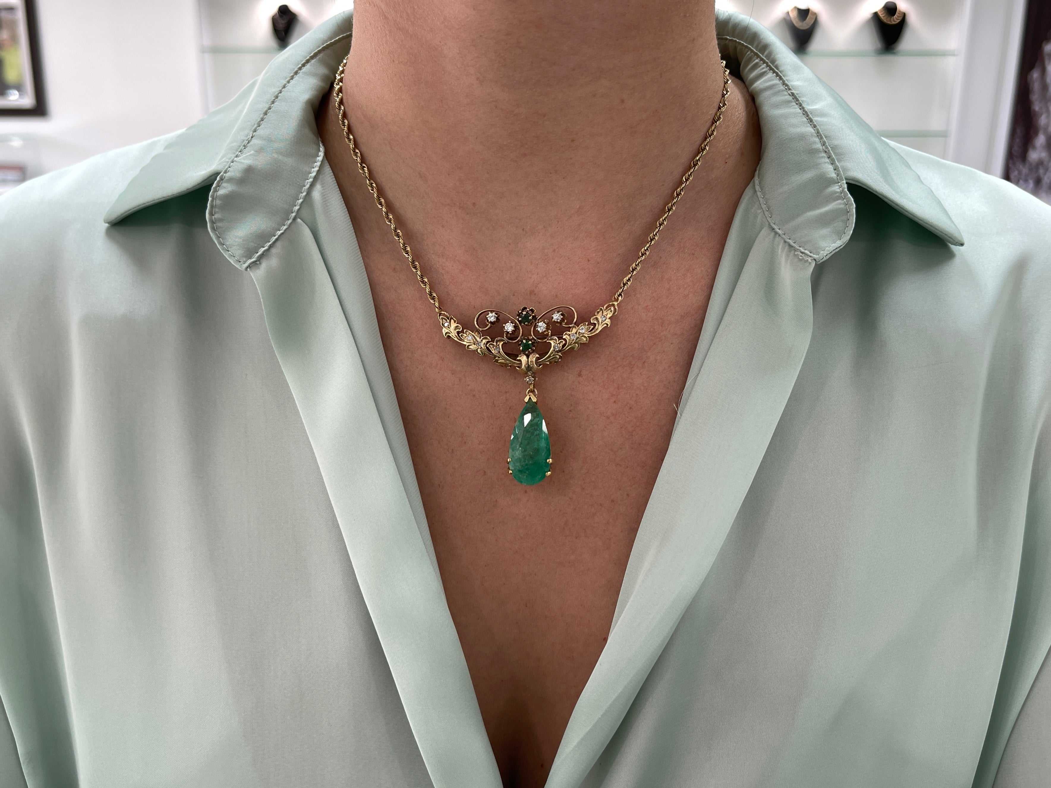 Vintage 14.97tcw pear-shaped Colombian emerald and diamond pendant necklace and brooch in 14K gold with intricate detailing.