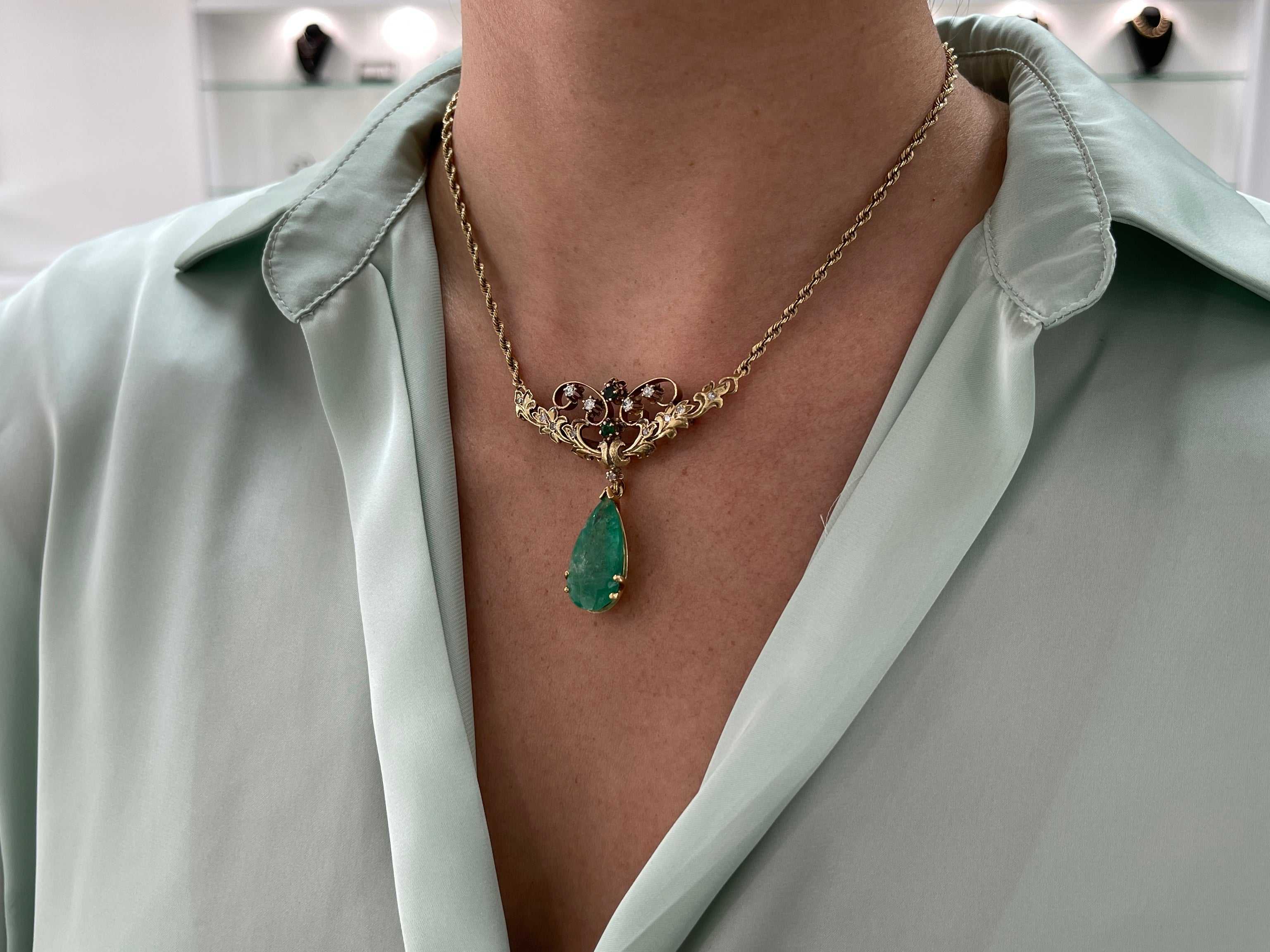 Vintage 14.97tcw pear-shaped Colombian emerald and diamond pendant necklace in 14K gold featuring a brooch design.