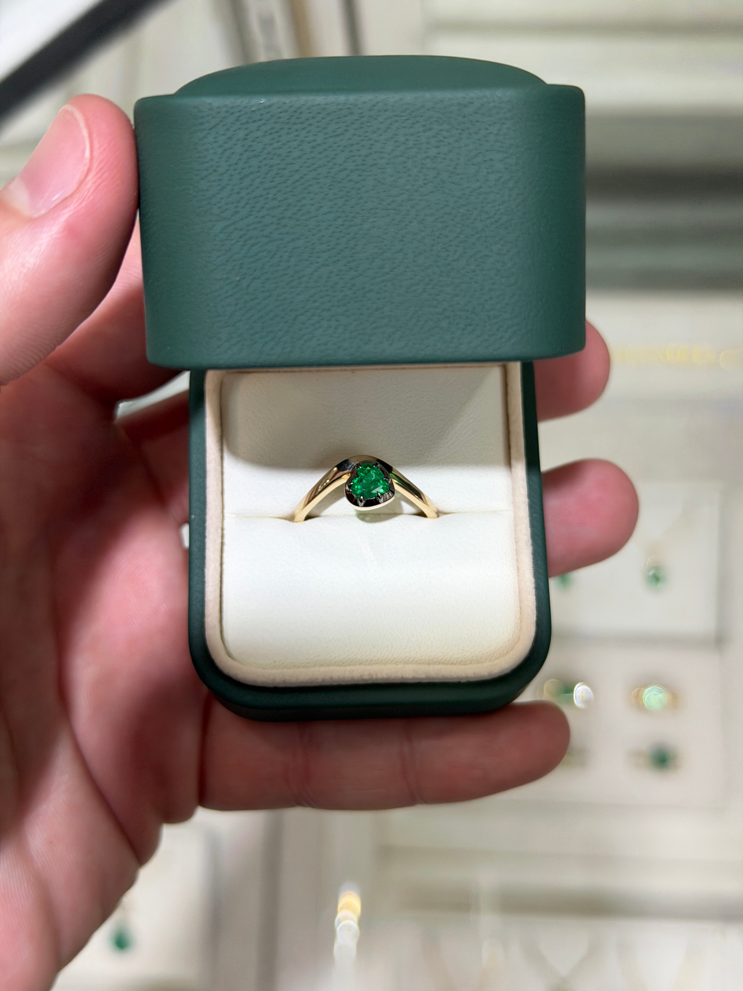 14K gold heart-cut emerald solitaire ring with black rhodium finish, featuring a 0.53ct emerald gemstone and multi-prong setting.