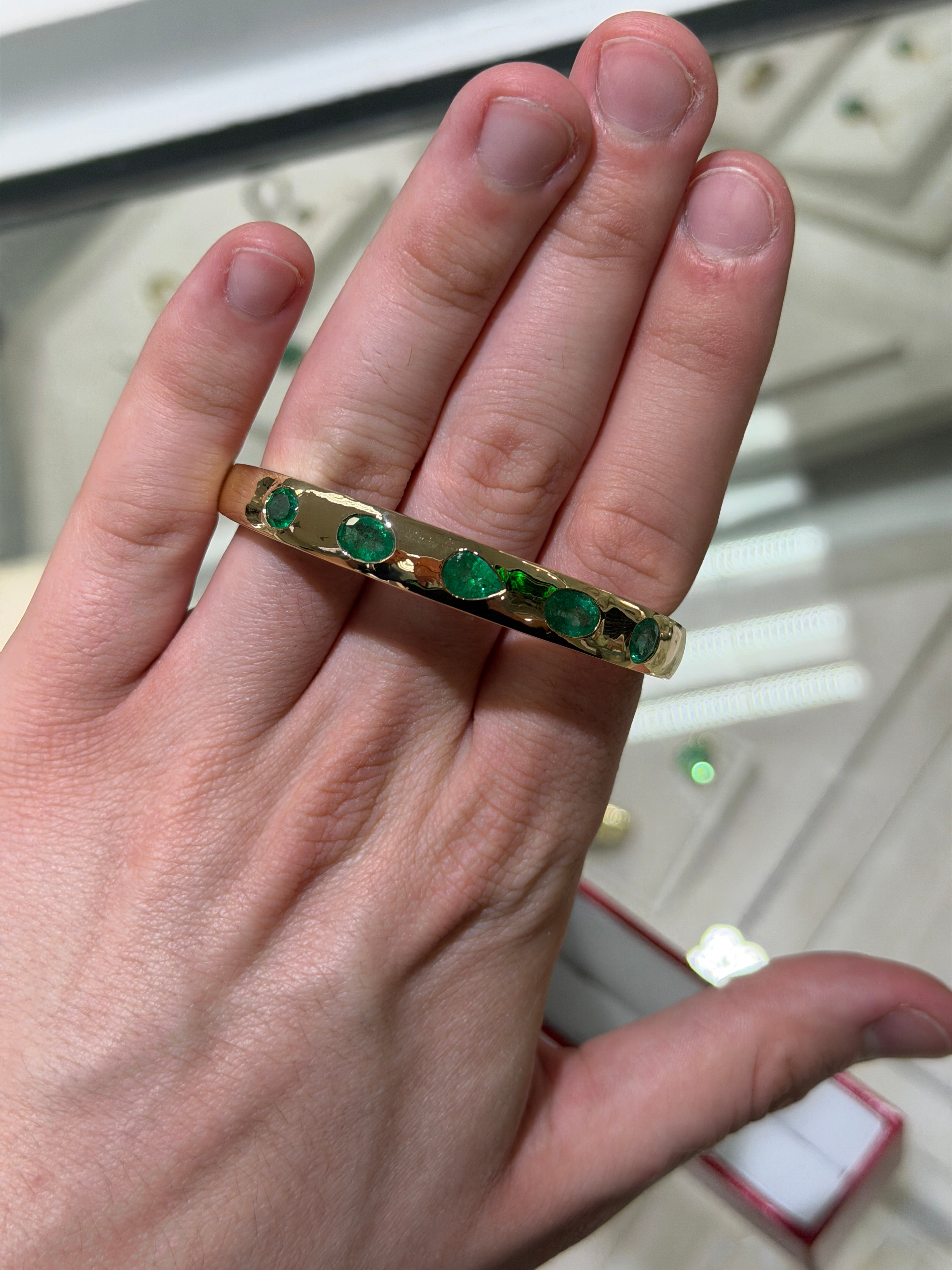 14K green emerald bangle bracelet with pear and oval cut gemstones, bezel set by JR Colombian Emeralds.