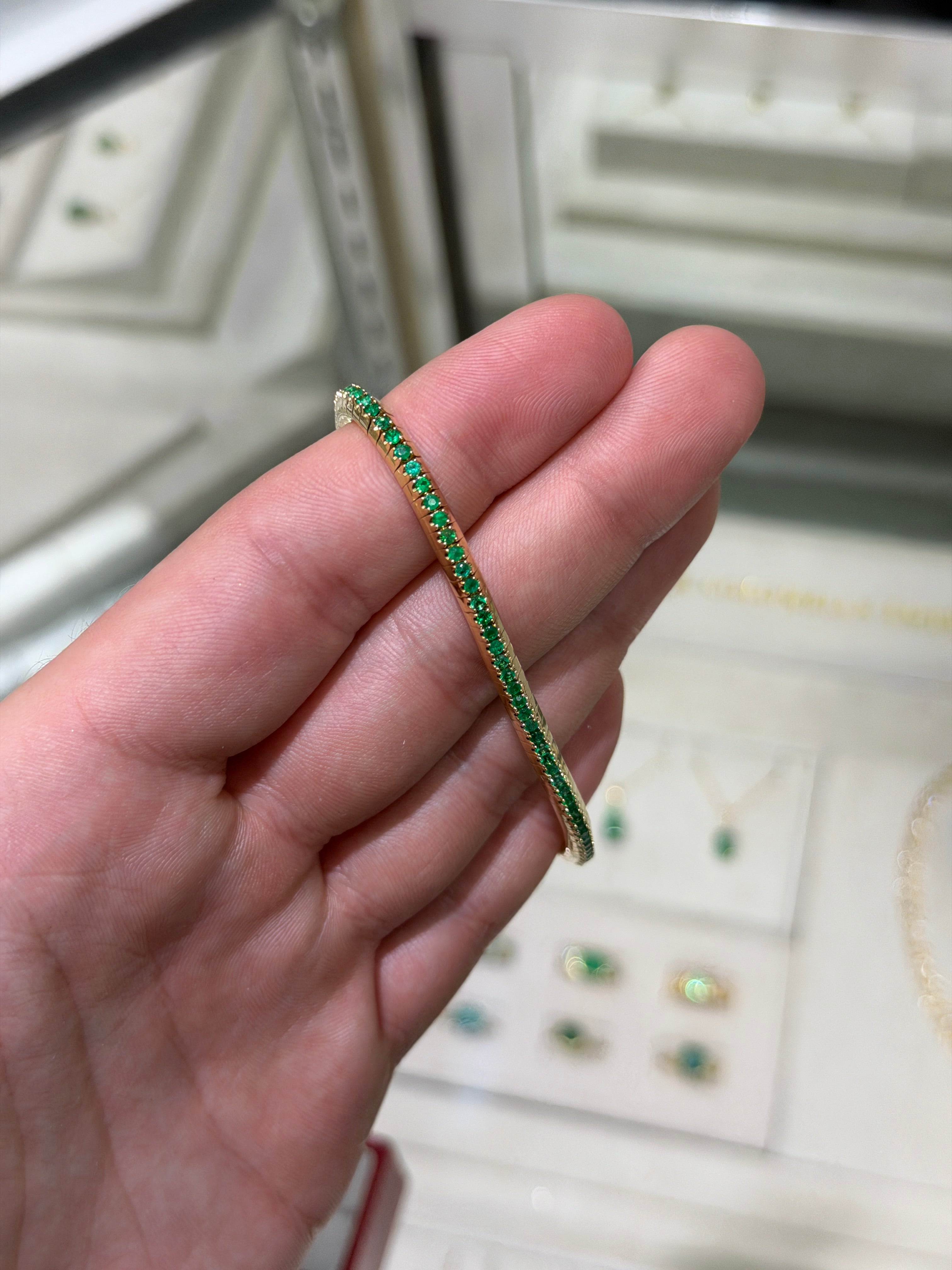 14K gold tennis bracelet with round emeralds totaling 3.30 carats, featuring a stretchy design by JR Colombian Emeralds.