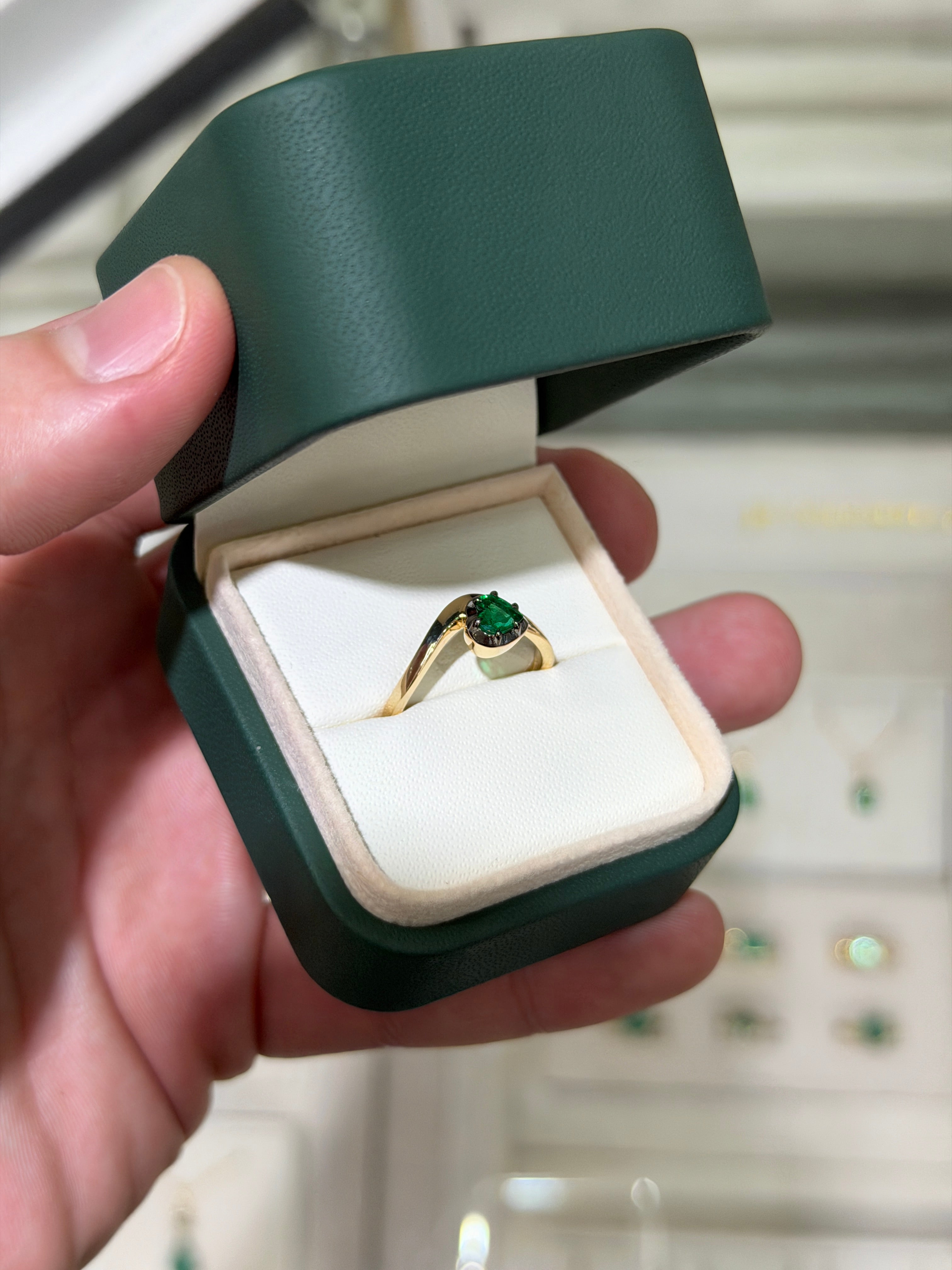 14K gold heart-cut emerald solitaire ring with black rhodium finish, featuring a 0.53ct emerald stone and multi-prong setting.