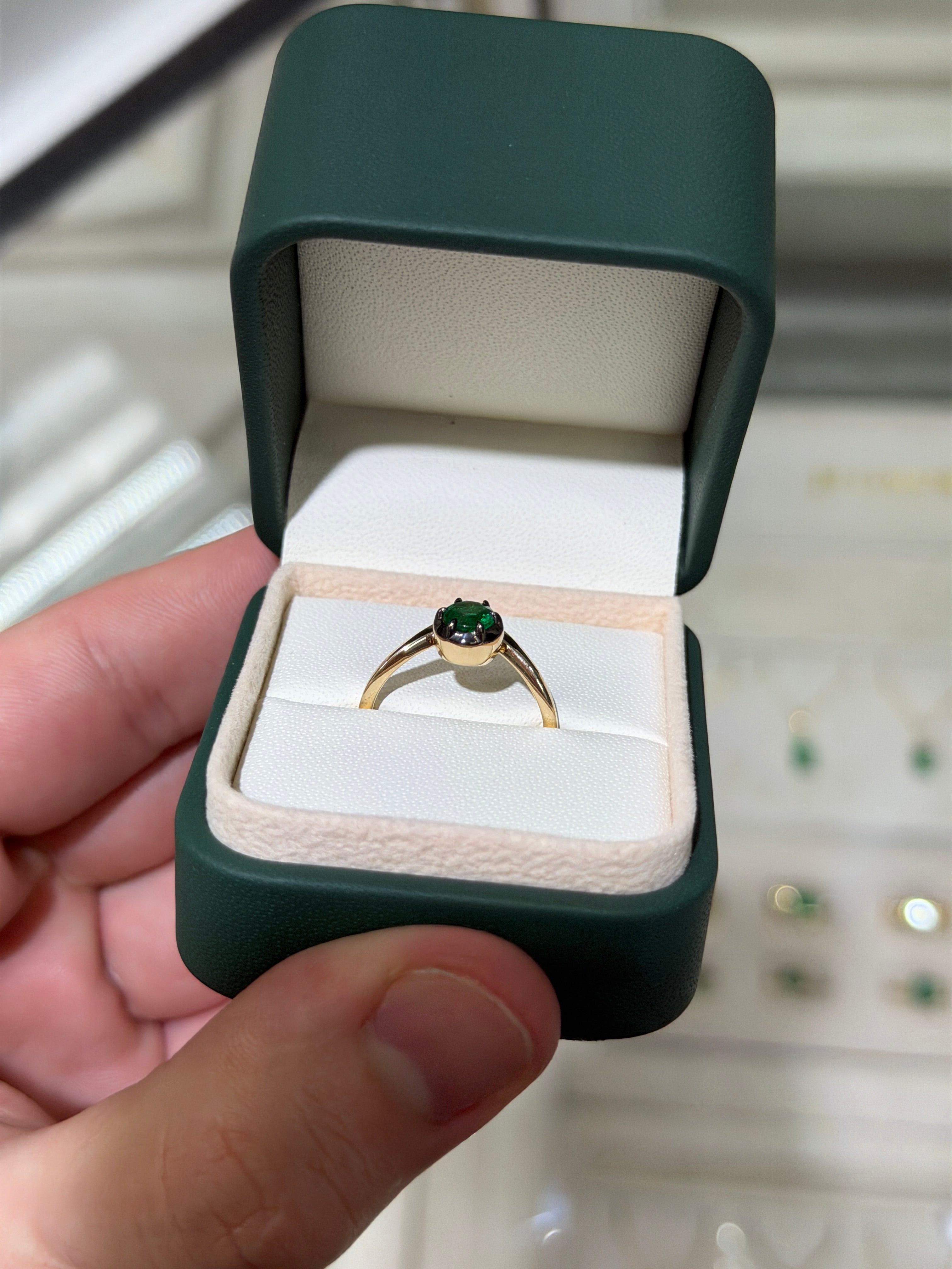 14K gold ladies emerald ring with a 0.64ct round cut emerald, solitaire design, multi-prong setting, black rhodium accents.