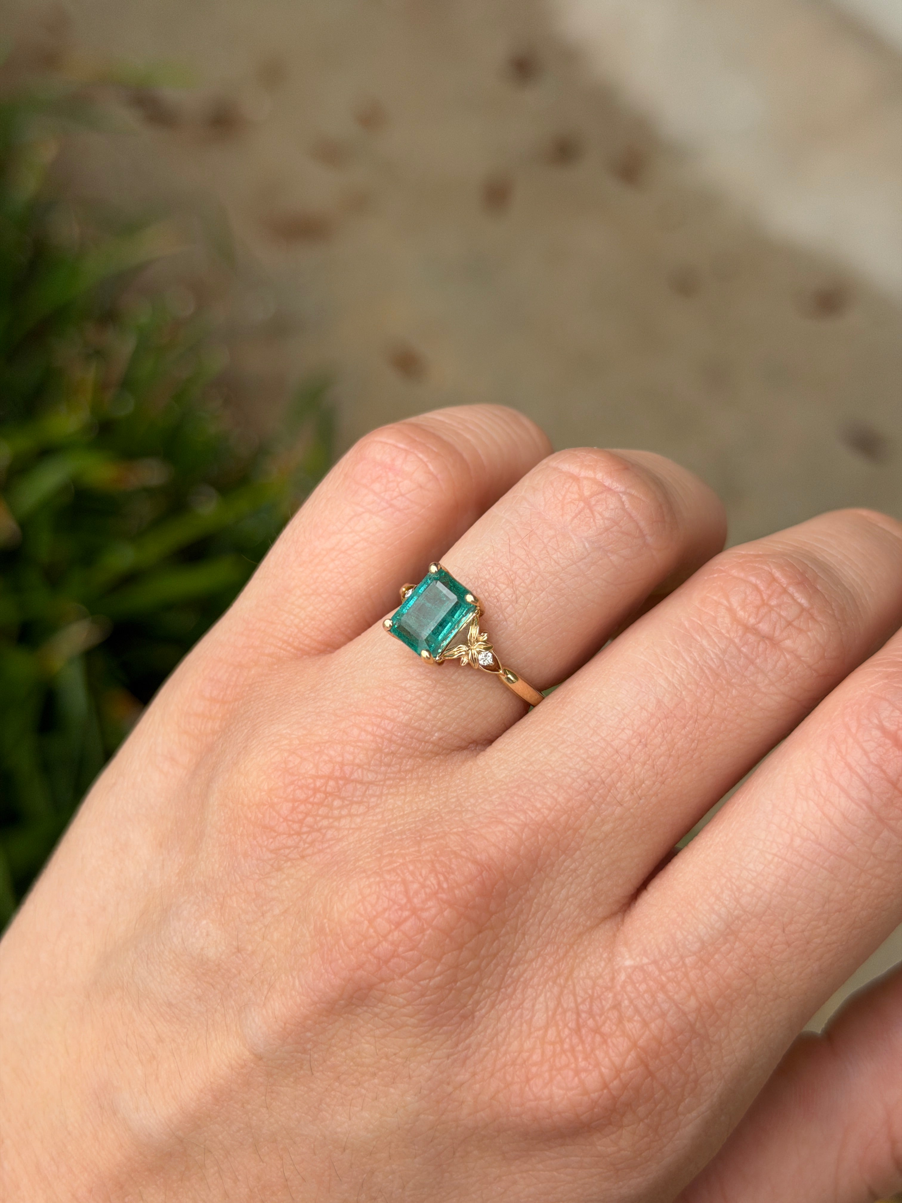 Anello solitario in oro 14 carati con smeraldo, impreziosito da diamanti sintetici per un totale di 2,30 carati, caratterizzato da una gemma centrale di smeraldo e da un design elegante.