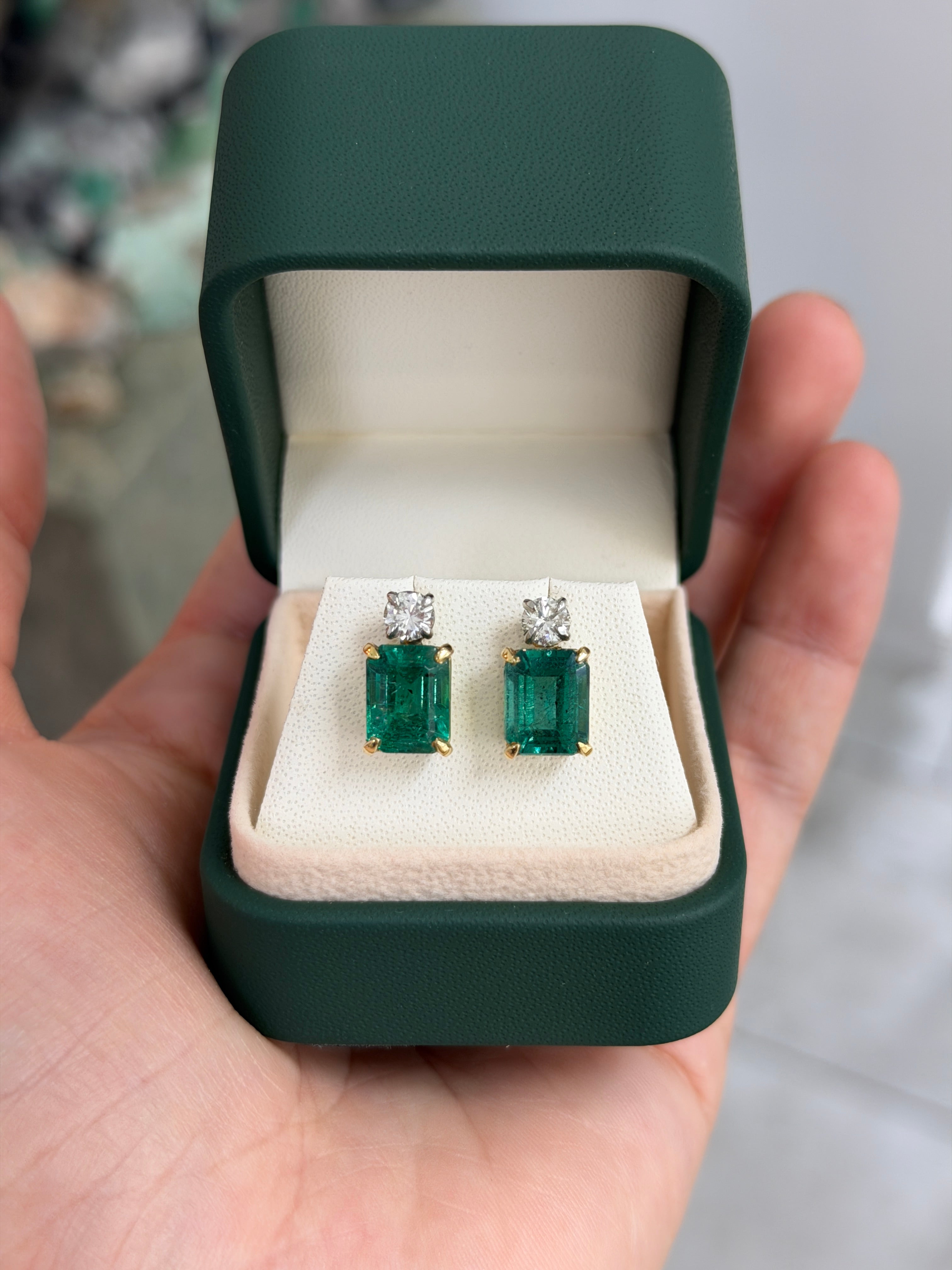 Colombian Emerald earrings with 7.20tcw natural emerald-cut and round diamonds in two-tone 18K gold with vivid sea deep bluish-green color.