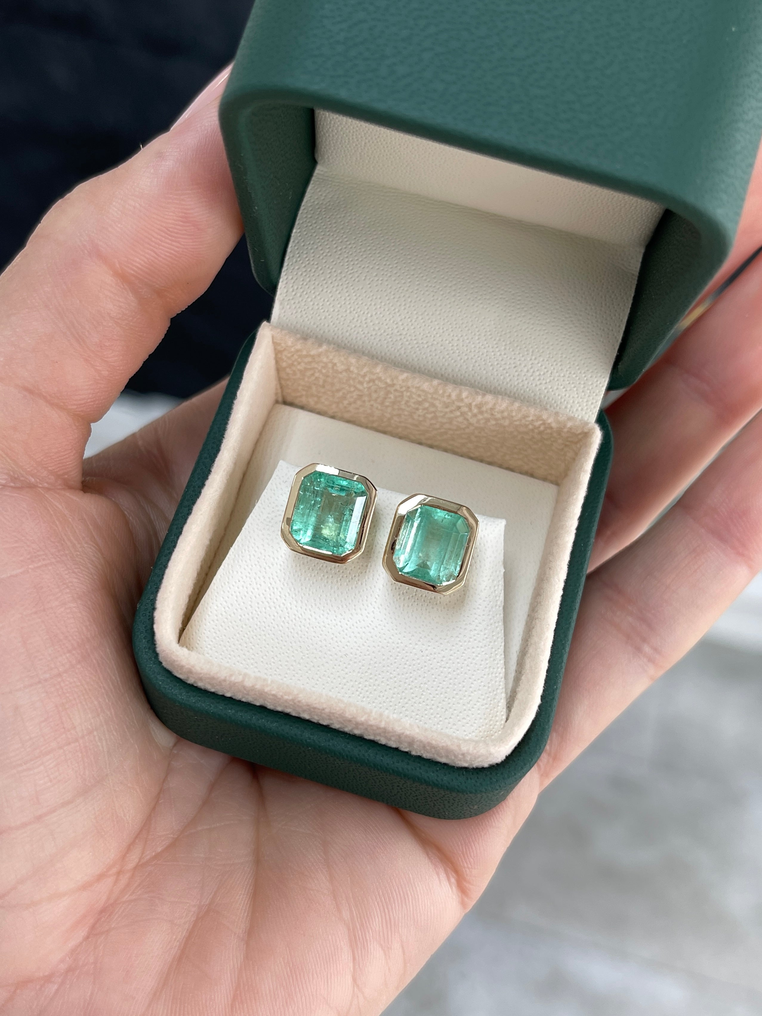 6.80tcw bezel set natural Colombian emerald stud earrings in 14K gold setting.